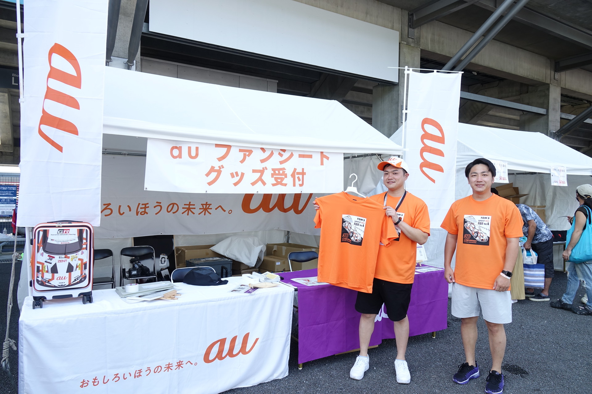 会場にはこんなau TOM'Sファンシートのブースがある