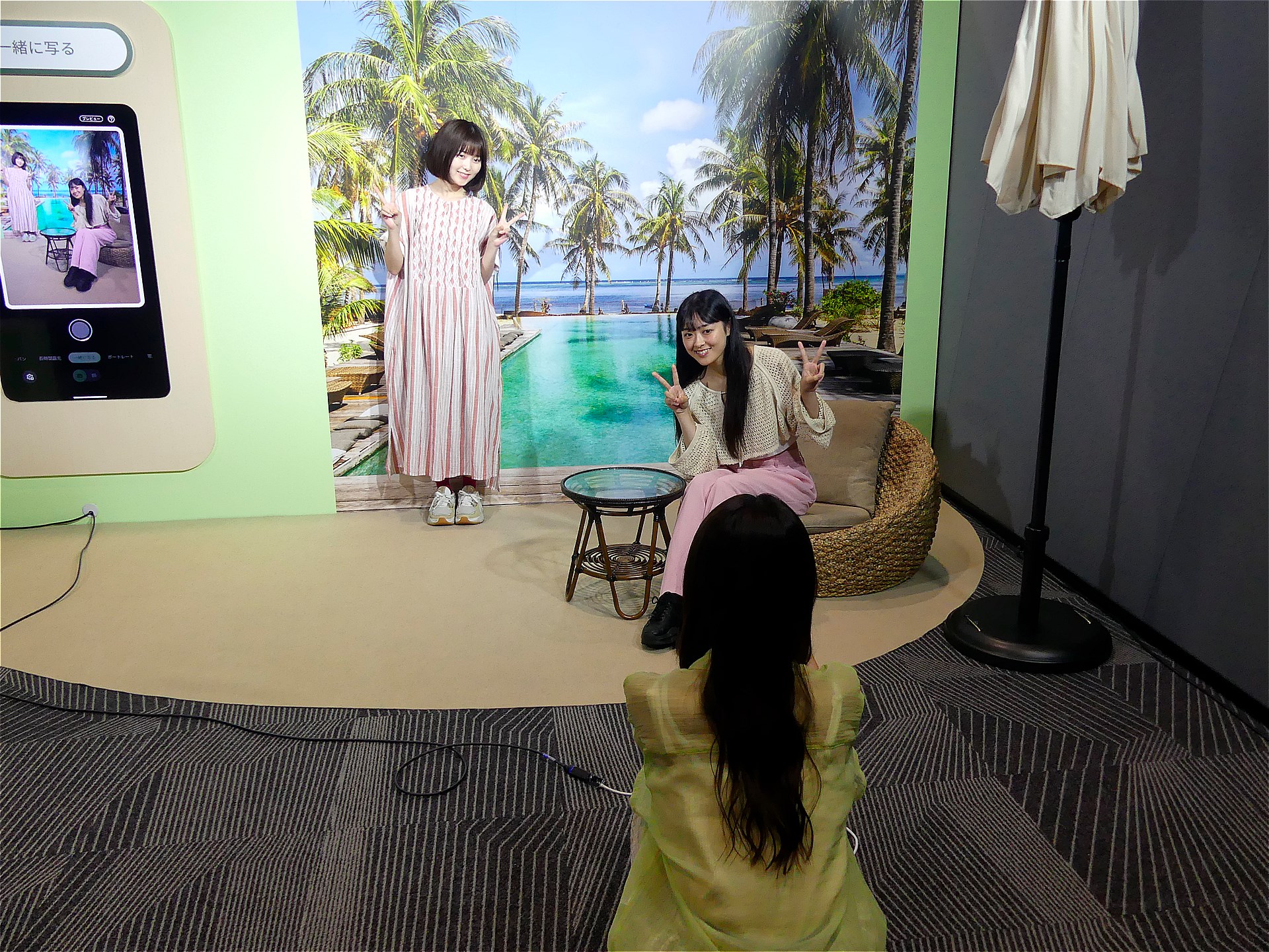 3人の集合写真を撮るシーン。後から1人加わることを考慮して2人の位置を決めて撮影。その後、撮影者だった残りの1人を、画面上の画像に合わせて撮影する。その後、1枚の写真に合成された集合写真ができあがる