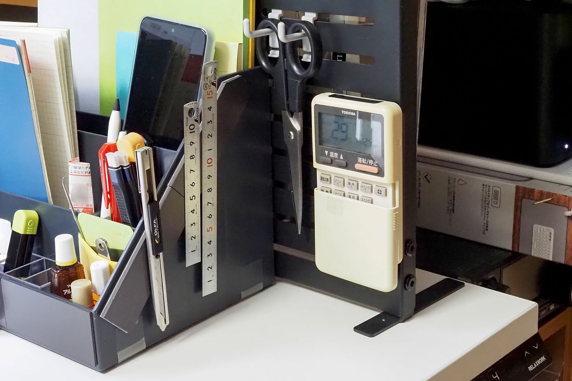 エアコンのリモコンもマグネット吸着。リモコンの裏側にマグネットシート（マグネットプレート）を貼っているので、スチール製のLIHIT LAB「ALTNA アレンジボード」に安定的にくっつく