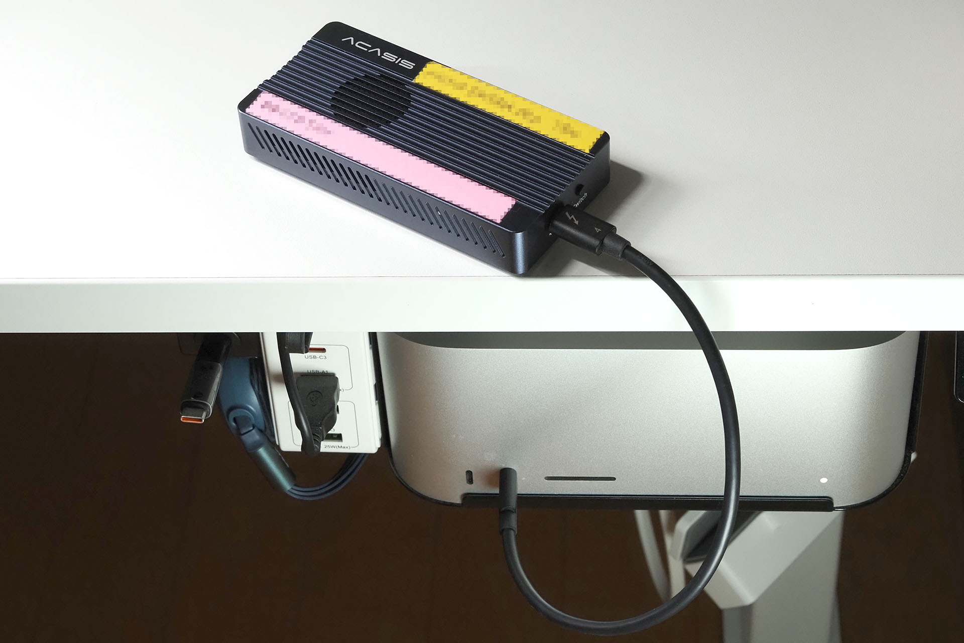 テスト運用中の前出エンクロージャー。Mac StudioのThunderbolt 4ポートにThunderbolt 4ケーブルで接続している。