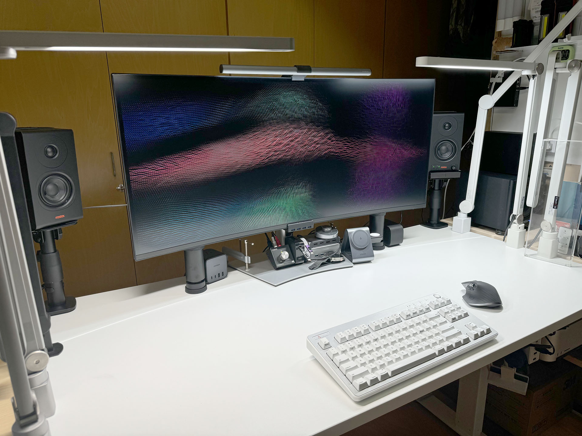 2024年9月の俺的デスクトップ。8月の20日頃にスピーカースタンドをセットし、そのツイデに棚板を追加しつつ片付けを進めた。その後、こんな状態がずっと続いている。机上には、たまにハードウェアやその箱が乗ったり、スマートフォンが横倒しになっていたりはするが、一度片付いて、使うモノの居場所がしっかり決まると、机上の整頓状態はその後も続いたりする。
