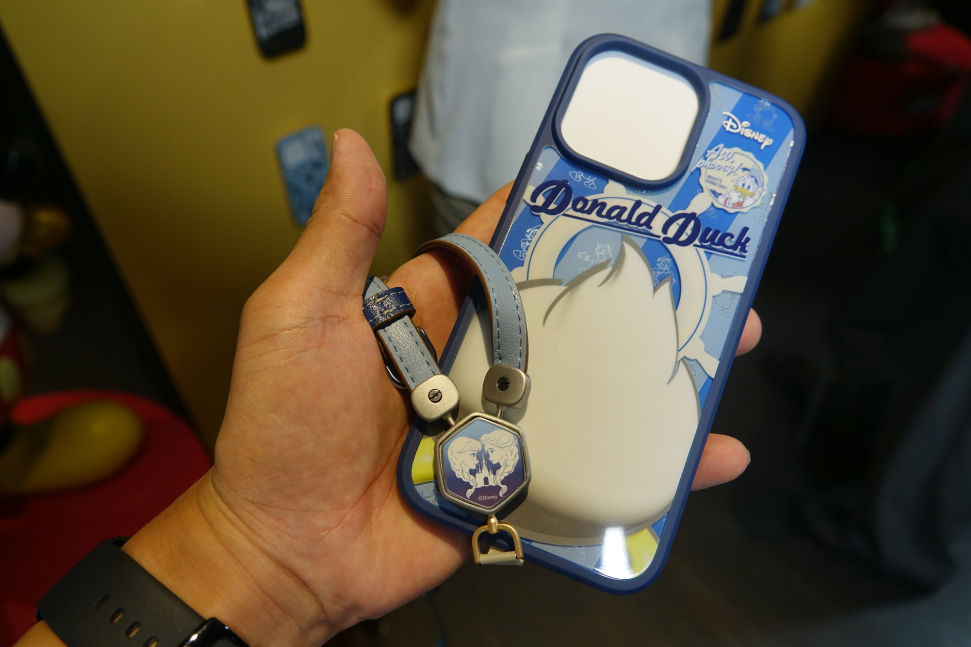 スマホショルダーストラップ。金具のプレートはマグネットによる脱着式。バックル部分は回転式で、背面を回転させることでロック解除され付け外しできる