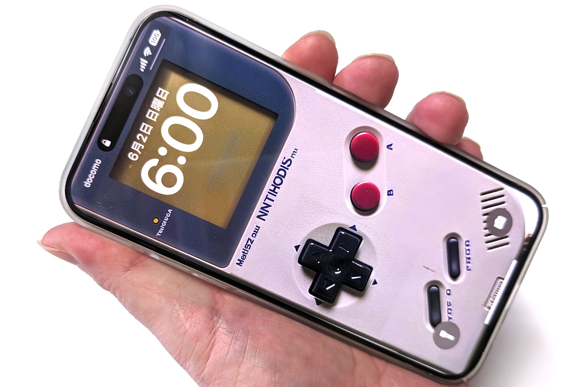 新型のゲームボーイをゲットしたゼ!!!　的なフェイク的写真。ゲームボーイっぽいハードウェア画像をAIに生成させ、それをiPhoneの壁紙として設定。そのiPhoneを手に持って撮影した。