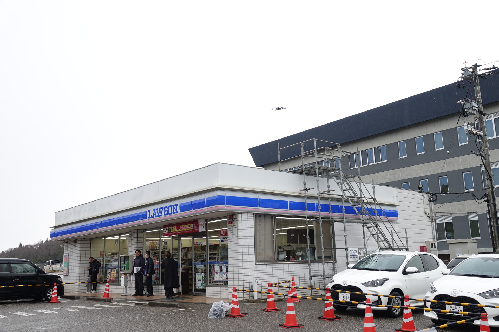ローソン屋上に設置されたポートから離陸するドローン（写真中央やや右）