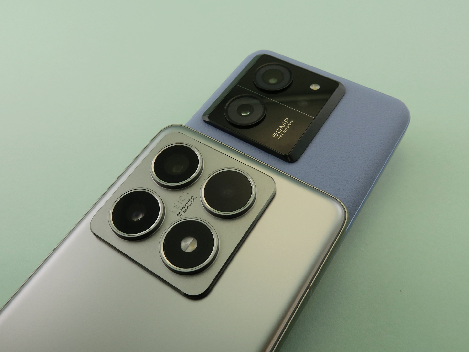 従来の「Xiaomi 13T Pro」（後ろ）から、「Xiaomi 14T Pro」（手前）はカメラ部のデザインが大きく変更された。レンズ部の中心には「LEICA VARIO-SUMMILUX」のネーミングも刻まれている