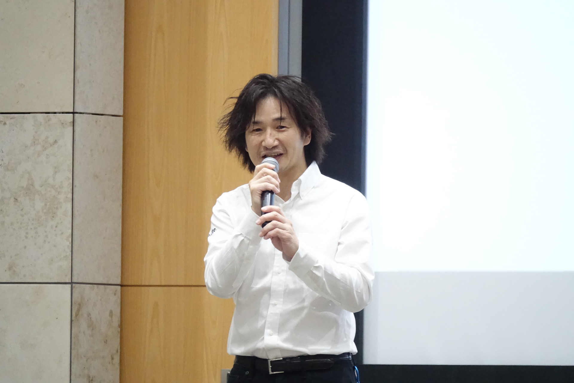 KDDI ブランドマネジメント部長の坂本伸一氏（左）もあいさつ。TOM'Sの神山裕示氏（右）もトークに参加した