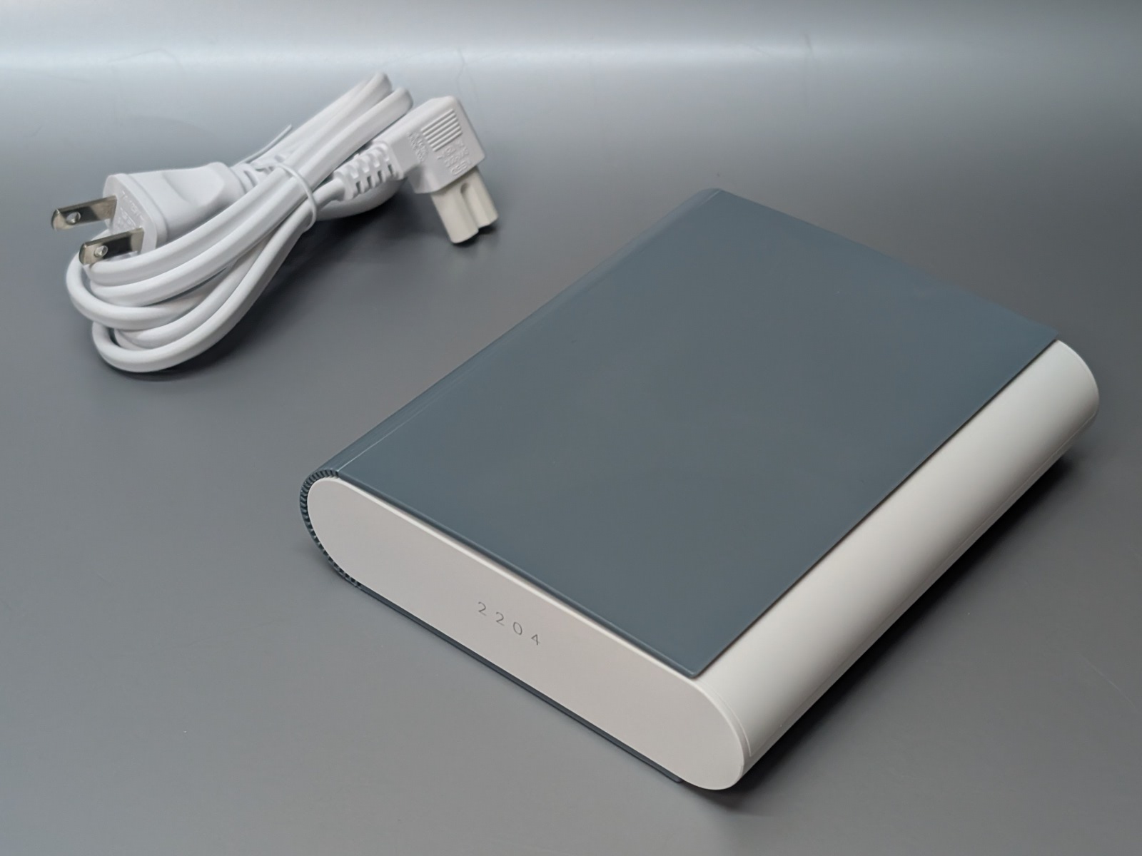 製品本体。ハードカバー本のような独特なデザイン。電源ケーブルが付属する