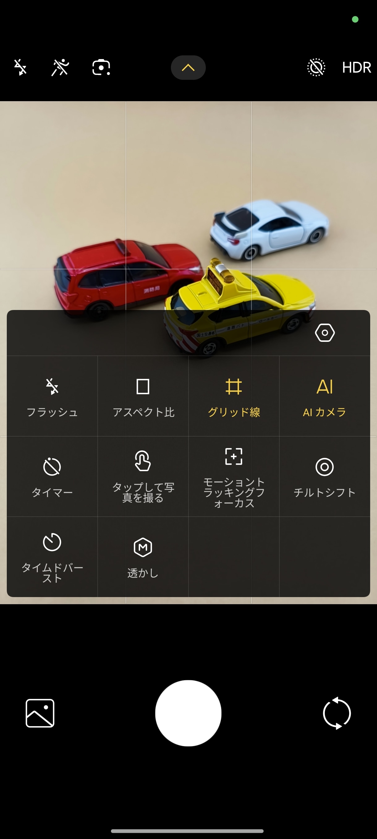 カメラのファインダーで最上段の［▽］をたっぷすると、よく使う機能のショートカット画面がオーバーレイ表示される。中段右上のアイコンをタップすれば、［設定］画面が表示される