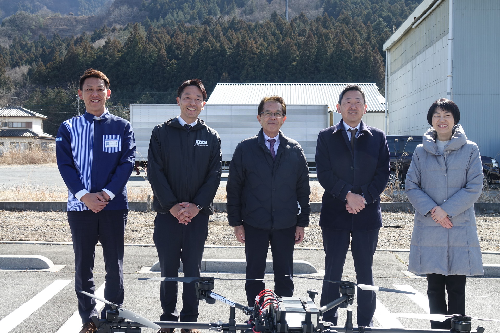 左からローソン 秩父荒川上田野店オーナー 石丸健氏、KDDI 事業創造本部 兼 KDDIスマートドローン ソリューションビジネス推進2部 部長 森嶋俊弘氏、秩父市 北堀篤市長、ローソン インキュベーションカンパニー 新規サービス部 シニアマネジャー 戸津茂人氏、環境省 水・大気環境局 モビリティ環境対策課 脱炭素モビリティ事業室 室長 中村真紀氏