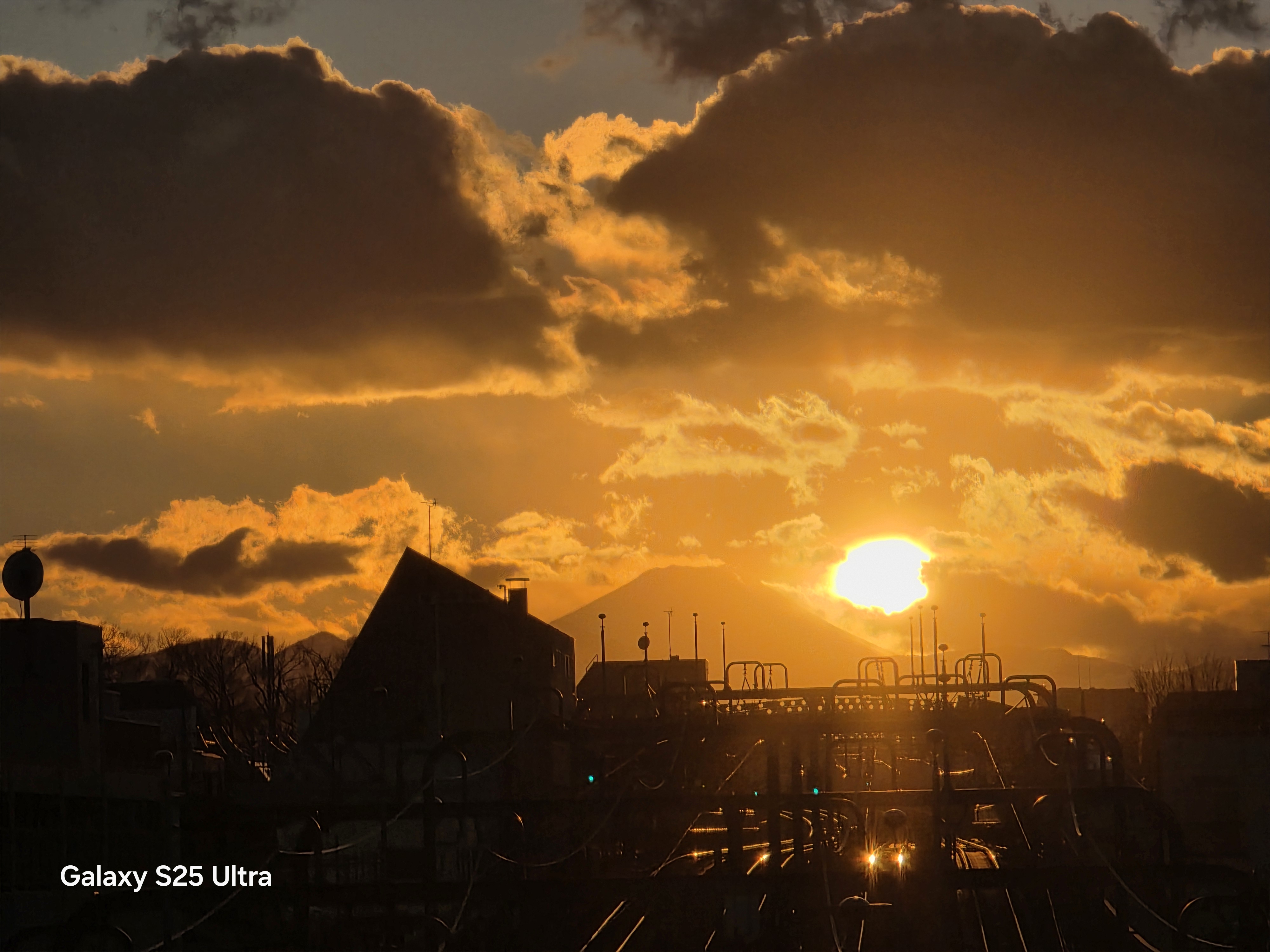 「Galaxy S25 Ultra」で夕景を望遠カメラ（光学5倍）で撮影。夕日の左側に見えるのは富士山。明暗のあるシーンでもきれいに撮影できる