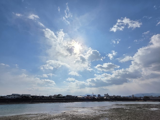 太陽を画面中央に入れてシャッターを切った。雲がかかってはいるがこのようなシチュエーションではクリーンな描写だ。干潟の様子や遠景の建物もしっかりと写しとっている
