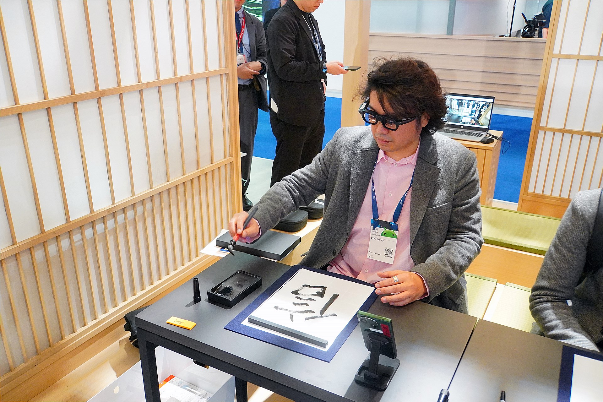 お手本に従いながら書道をする筆者