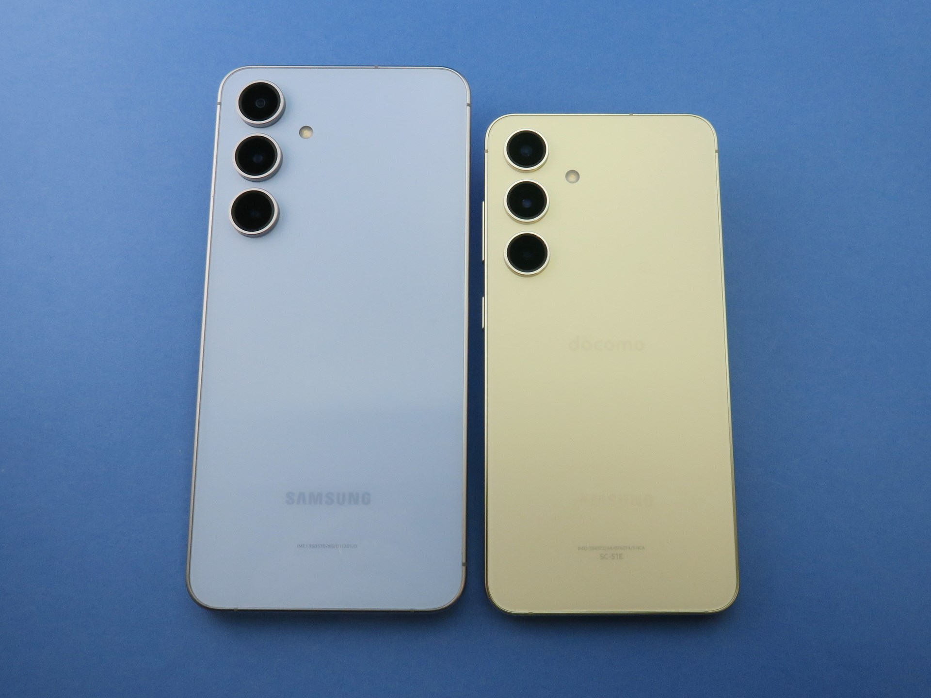 「Galaxy S24 FE」（左）と「Galaxy S24」（右）の背面。カメラなどのレイアウトは同じだが、幅で6.4mm、高さ（長さ）が25mmほど大きい