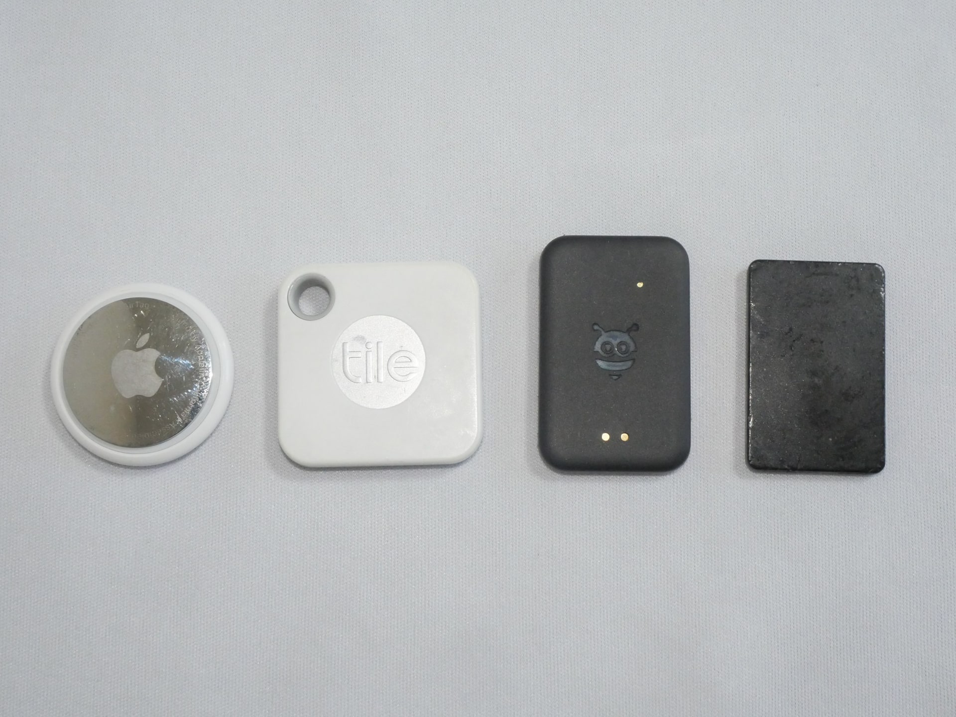 筆者が使用しているスマートタグを並べてみたところ（使用感はご容赦いただきたい）。左から「AirTag」「Tile Mate（2020年モデル）」「Pebblebee（タグ型）」「MAMORIO RE」となるが、タグ型Pebblebeeは他と比べても大きさ的に大きな違いはない