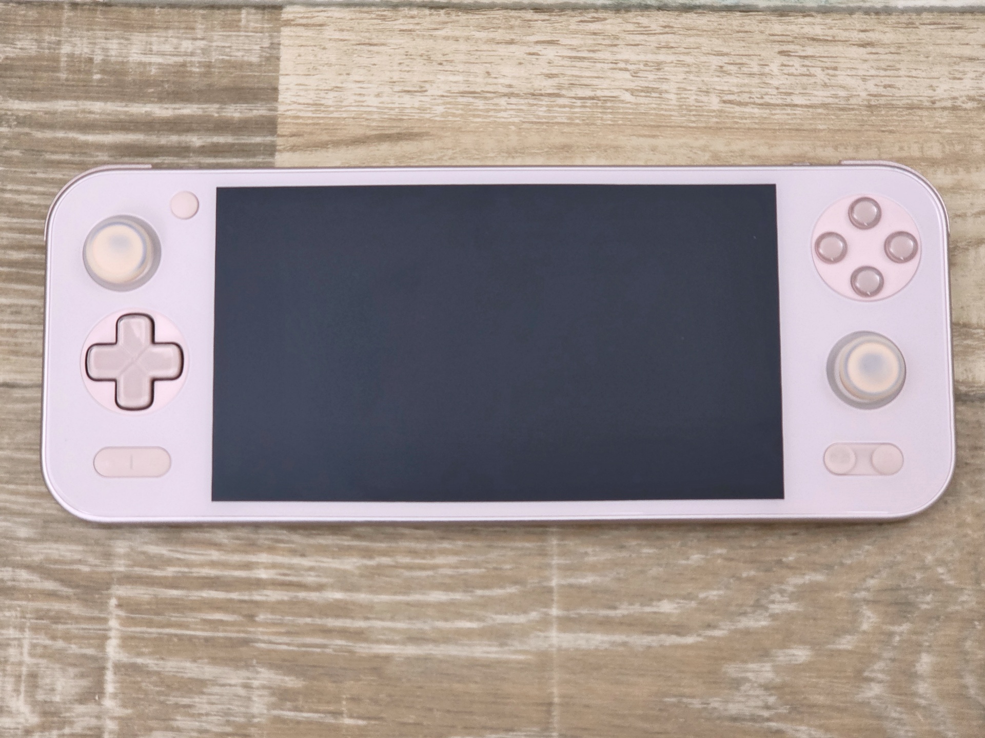 周りの“ガヤ”を取り除いた状態のAYANEO Pocket S さくらピンクの前面。6型IPSパネルの両側にコントローラーを備える