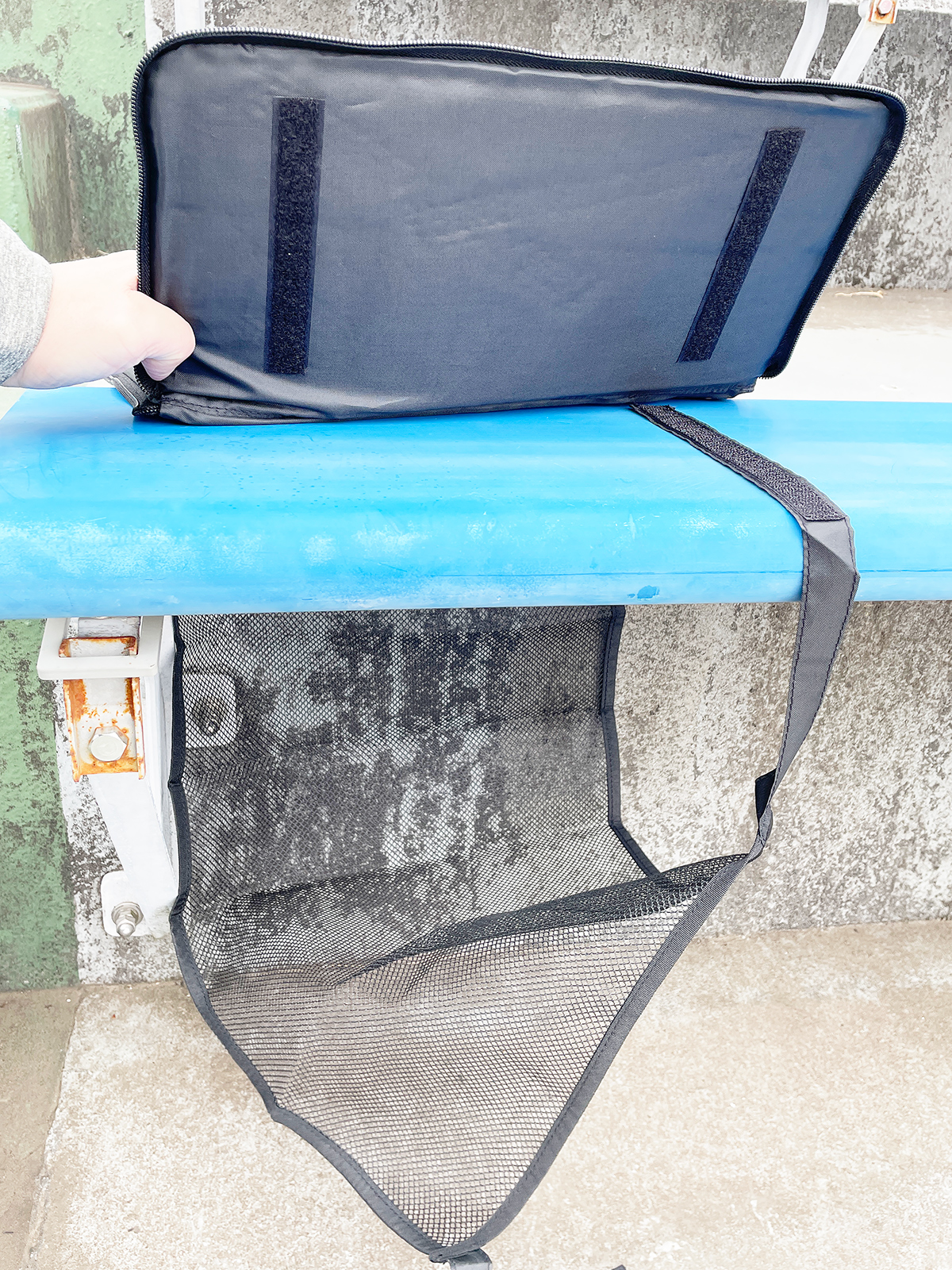 座面の背後からネットをぐるっと回し、ネットの紐をクッションの下部の面ファスナーに留めます。