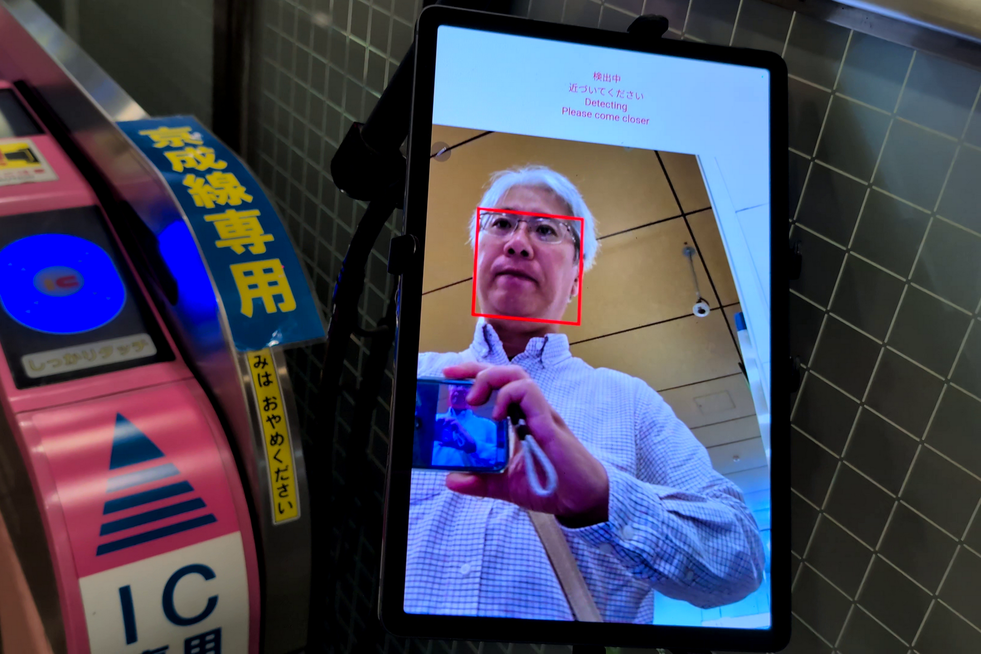 iPadと思われるタブレットに近付くと、顔を検知して、あらかじめ登録した顔情報を利用して認証が行われる