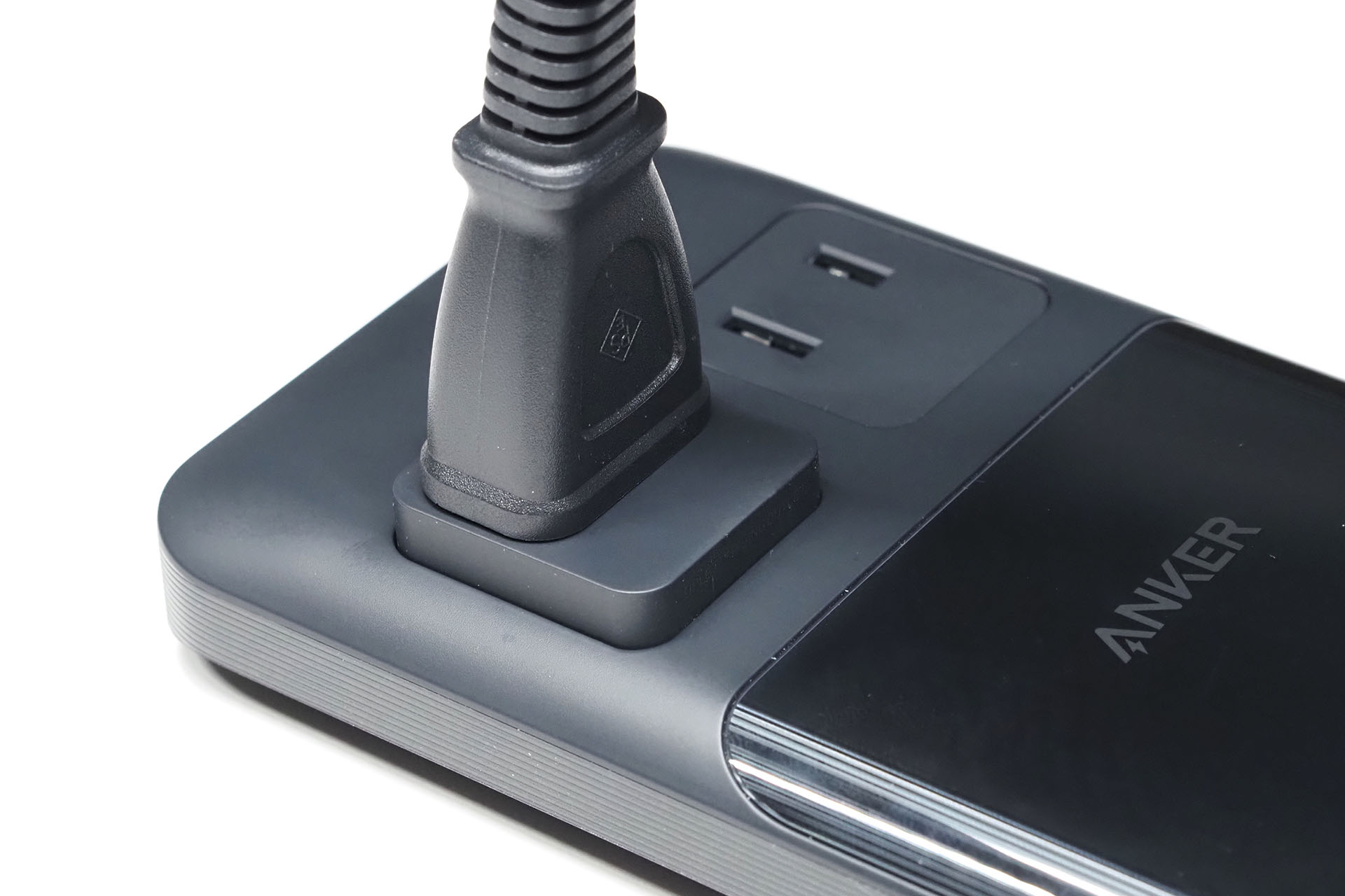 ACプラグを挿すとコンセントがせり上がる独自の機構を備える。挿していない場合は奥のコンセントのように本体に格納されるカタチ。