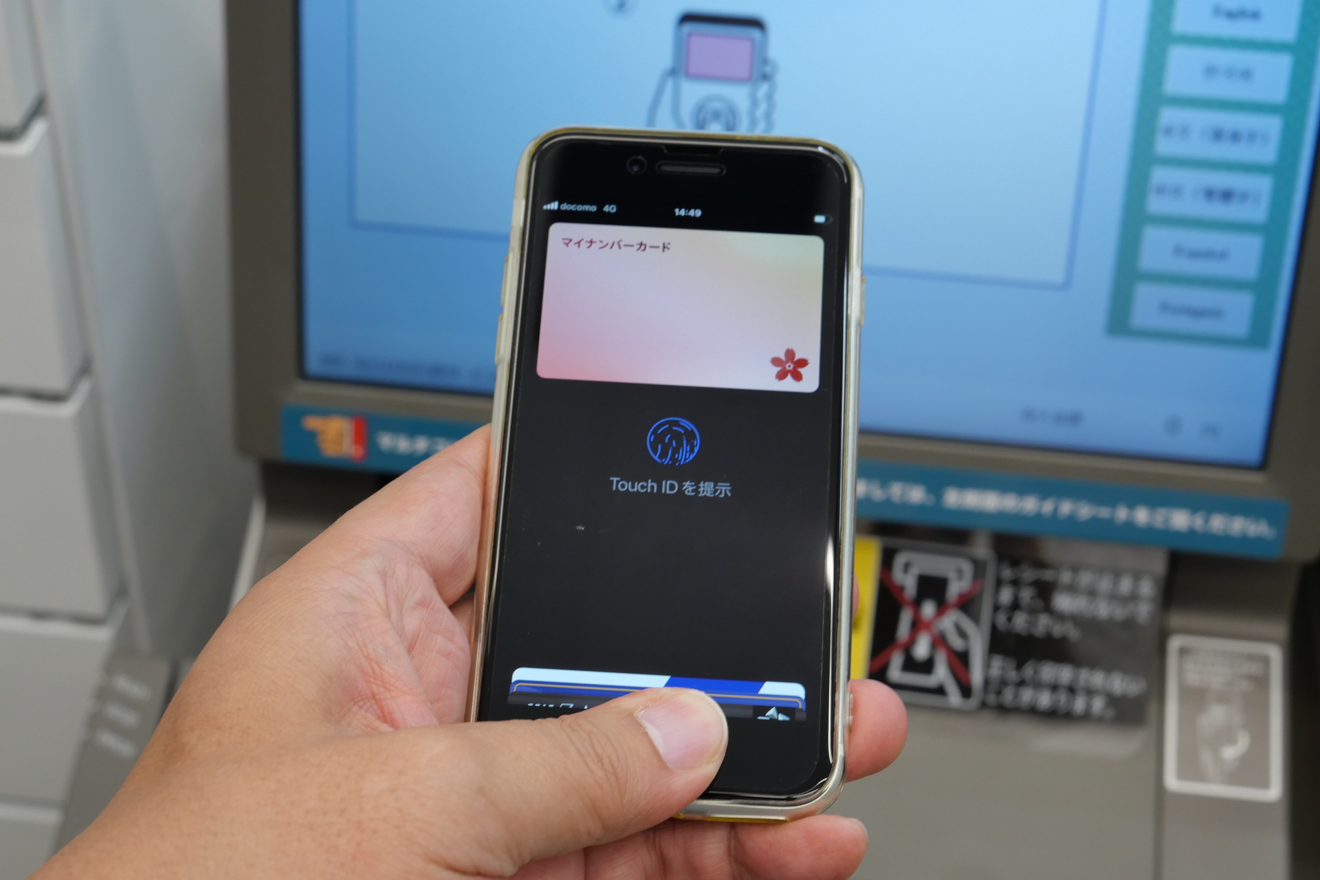iPhoneでAppleウォレットを開き、マイナンバーカードを表示してTouch IDまたはFace IDで認証（写真は別のタイミングで撮影したもの）