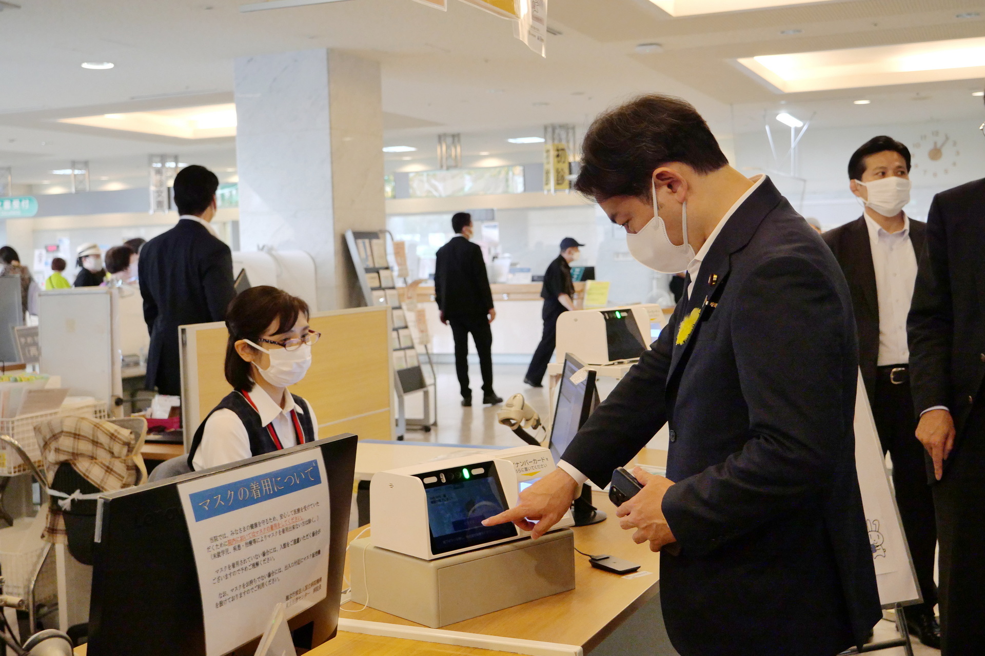 自身のスマホでマイナ保険証の利用を体験する福岡厚生労働大臣