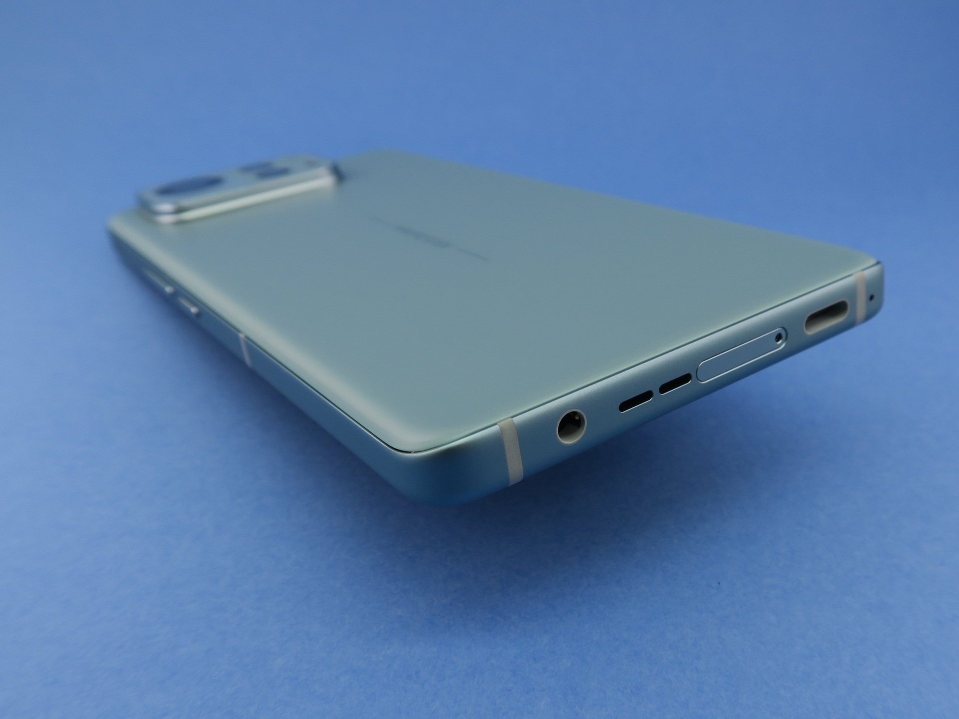 本体下部は左側面寄り（写真内右側）にUSB Type-C外部接続端子、中央付近にピンで取り出すタイプのSIMカードスロット、右側面寄り（写真内左側）に3.5mm径のヘッドホンジャックを備える