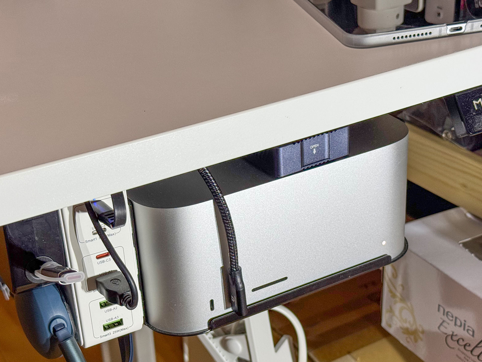 そこでMac Studioと机の間の空間にケース入りSSDを設置。これでしばらく常時接続運用したが、机上に置いたときよりも熱をもっていた。SSDケースの裏面に触れたら、けっこう熱くなっていた。手に持っていられないってほどではないが、「この発熱でずっと運用は……どうなの？」「連続読み書きとかしたらもっと熱くなるだろうし」と少し不安になった。