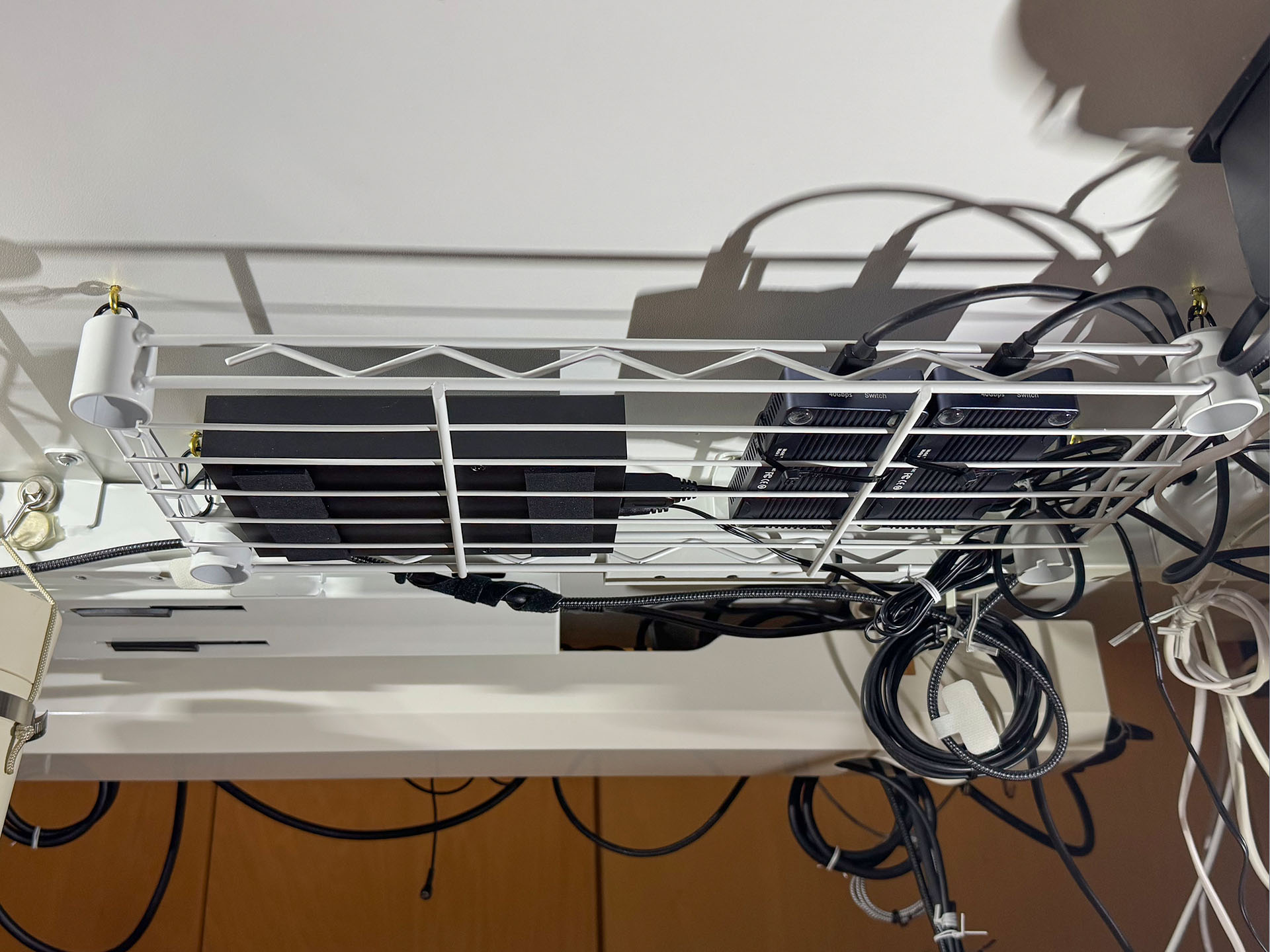 机の下に網状の棚を設置し、その上にSSD×2台とHDD×1台を置いた。SSD上部空間は手のひらが入るくらい余裕がある。そんな空間があるので、ときどき手でSSDケースに触れて温度を確かめられる。