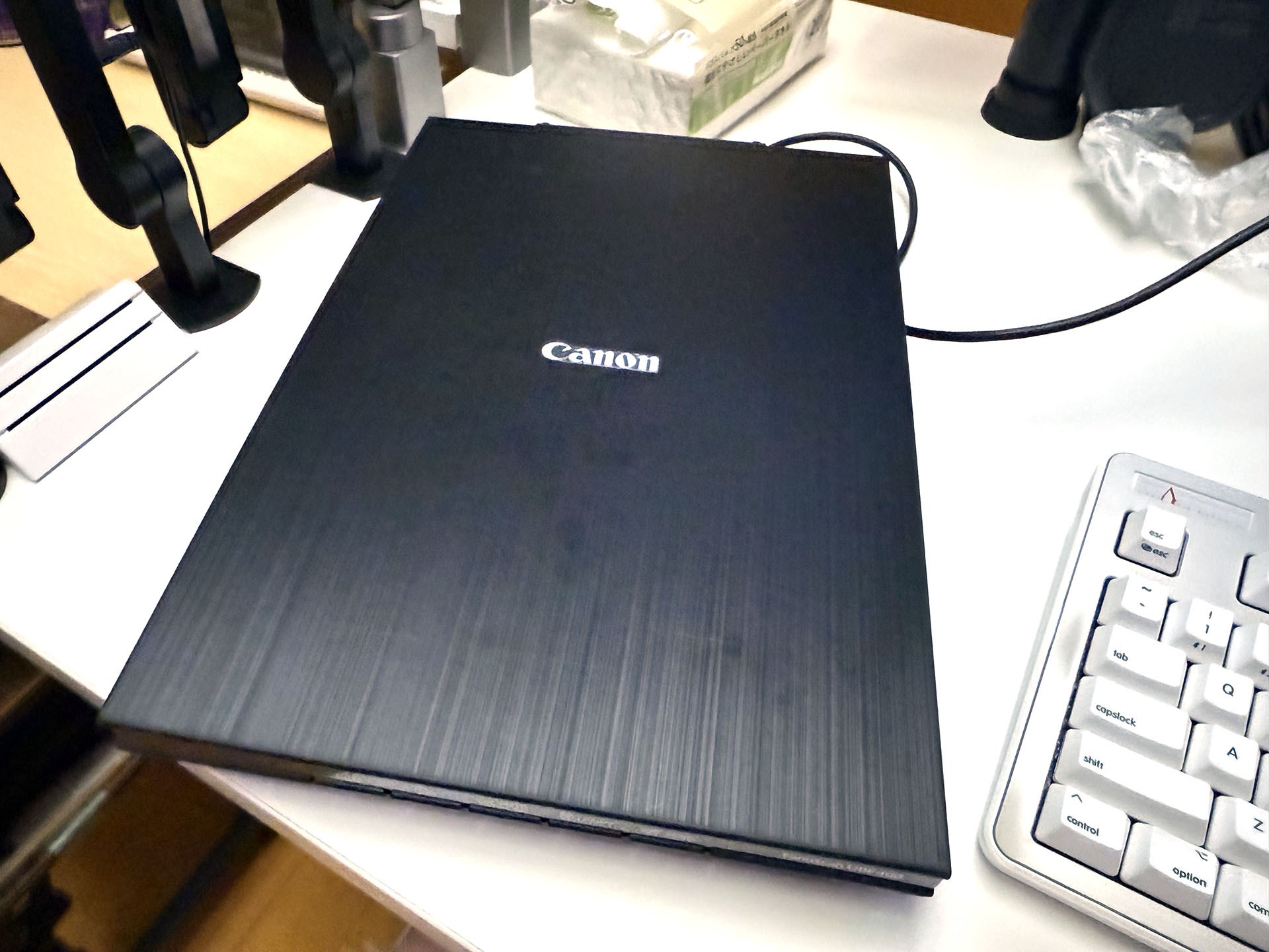 ディスプレイやキーボードの左側にCanoScan LiDE 400を置いて使用。左手で原稿をセットして右手（マウス）でアプリ（VueScan）をコントロール。