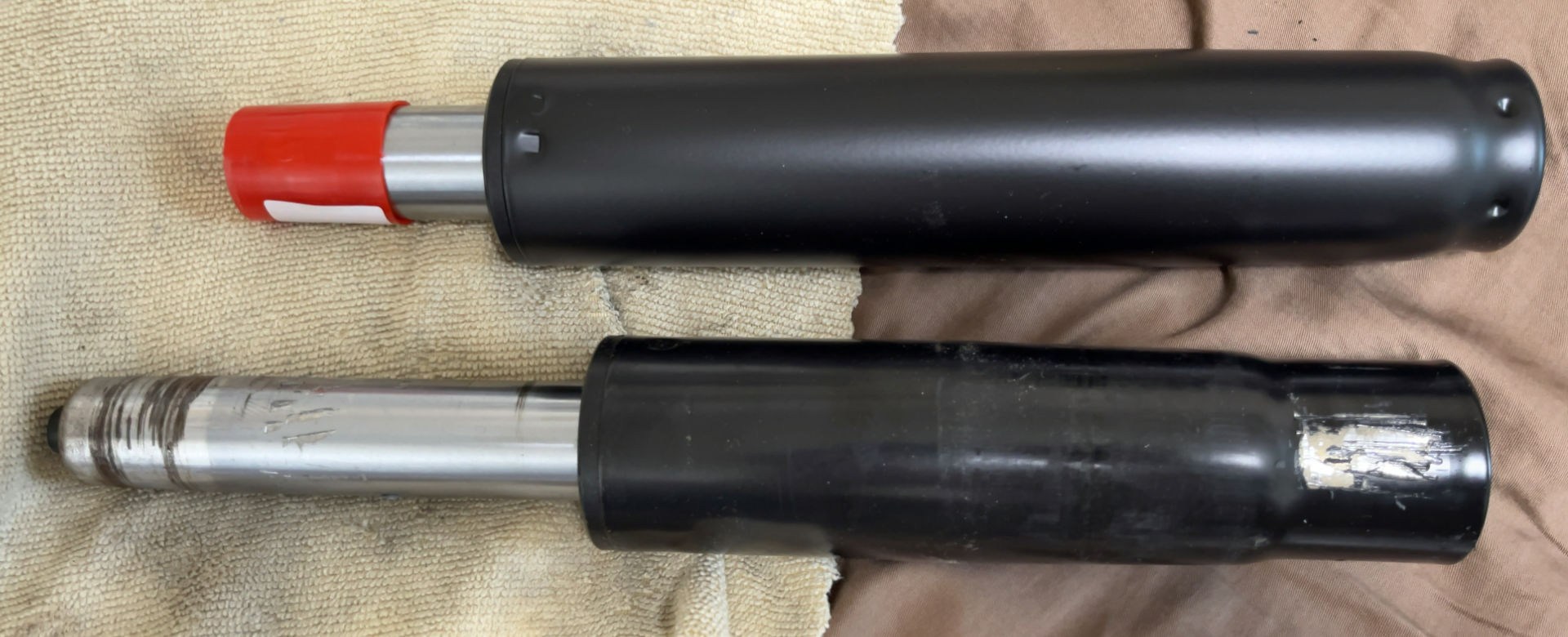 新旧ガスシリンダー。上（新品）は最短状態、下（旧品）は最長状態。旧品はサビが出ている。