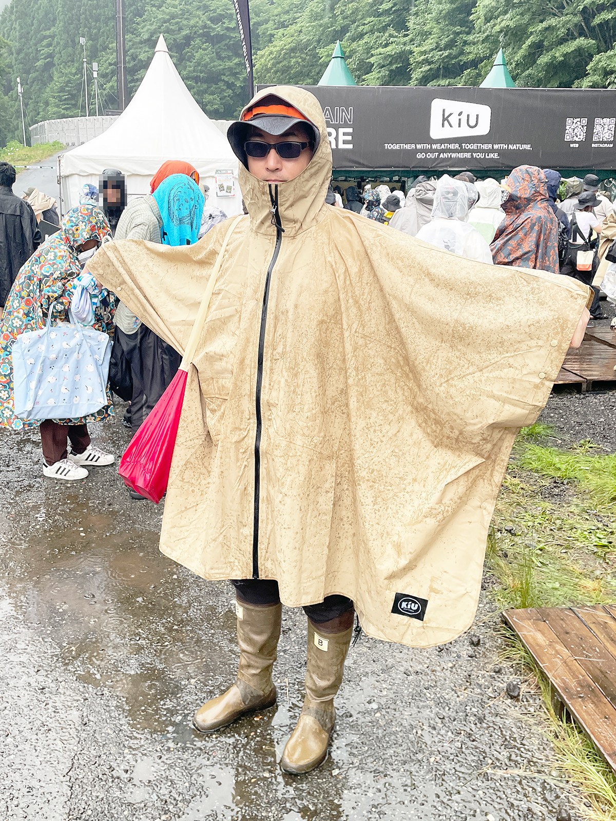 案の定、大雨に見舞われてレインポンチョを着込む筆者。フードが深く顔も保護してくれるので雨からほぼ完璧に守ってくれます。