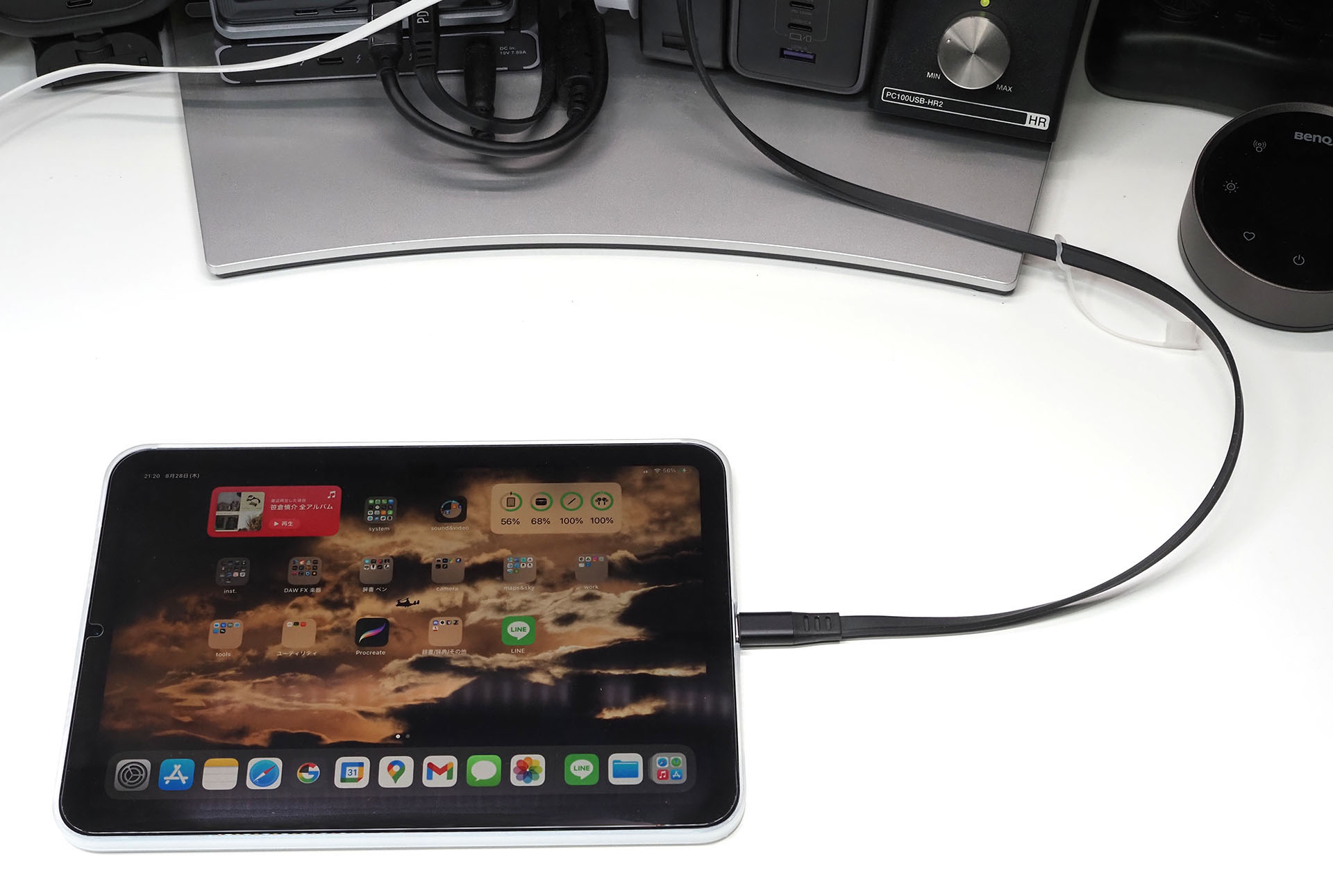 机上でiPad miniを充電中。これまではこんなふうだった。ケーブルが右に大きく出てカーブして充電器につながっている。