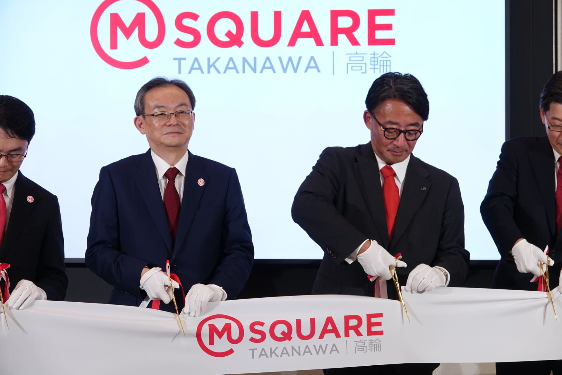 テープカットで鋏を入れる半沢氏と喜㔟氏