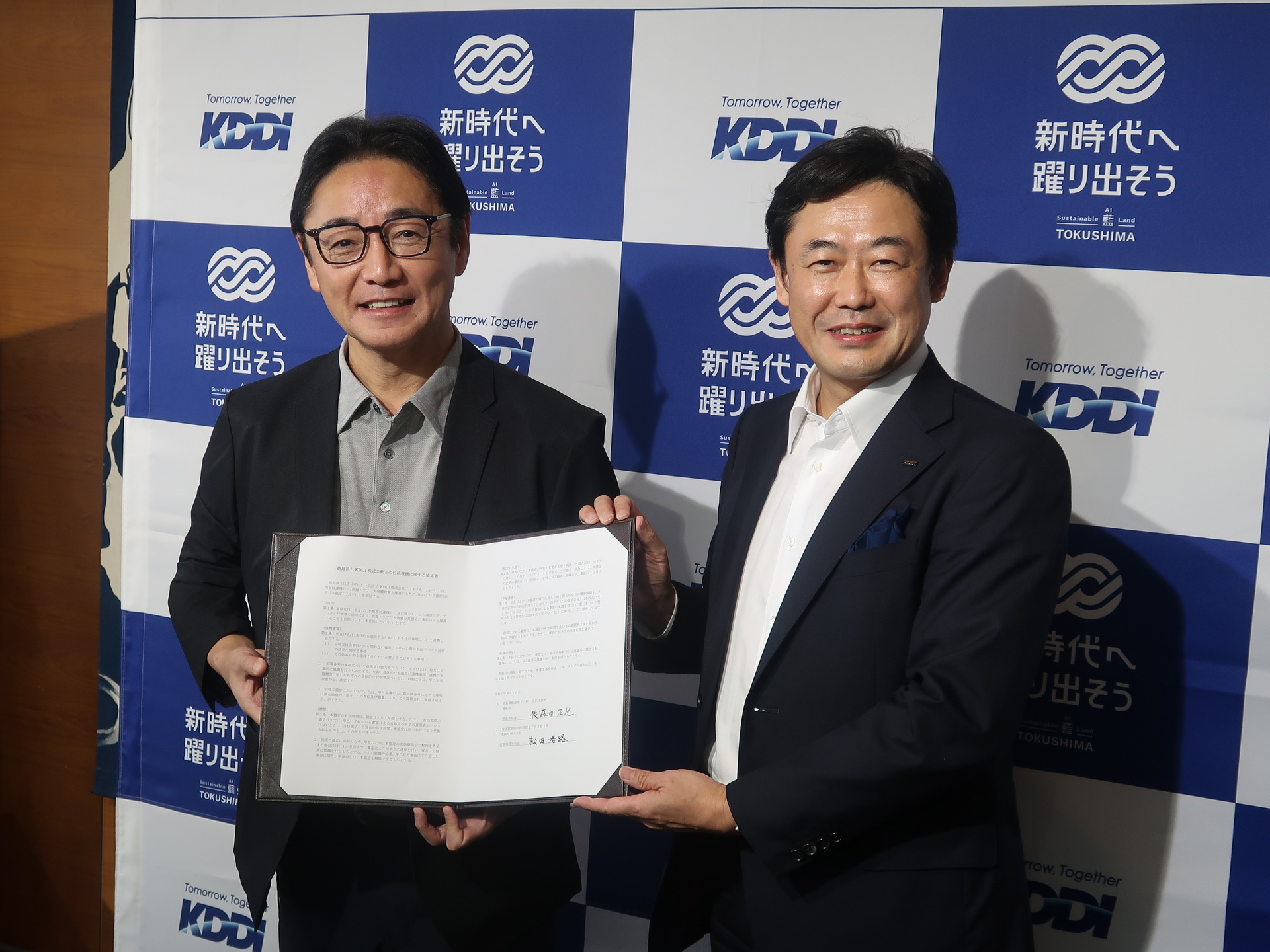 署名した協定書を掲げる後藤田知事と松田社長