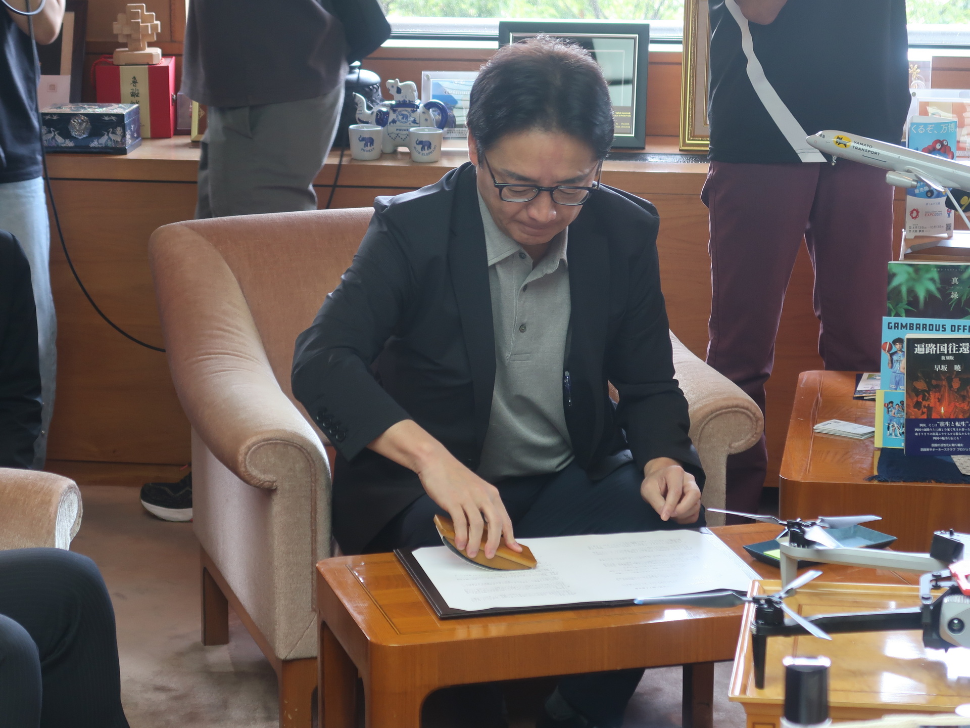 署名した協定書をきれいに仕上げる後藤田知事