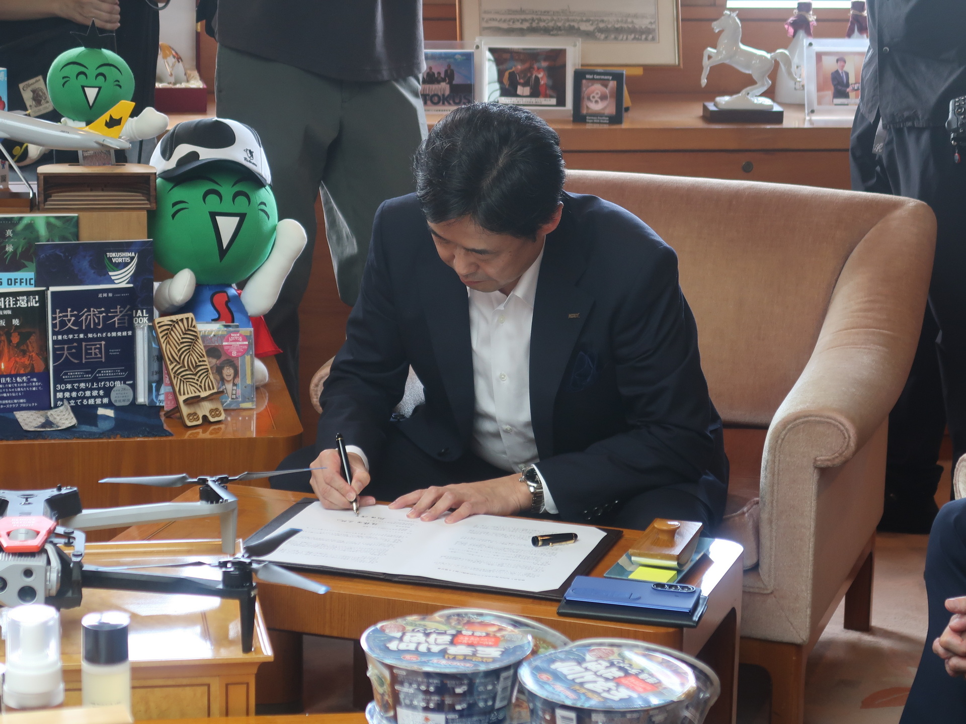 協定書に署名する松田社長