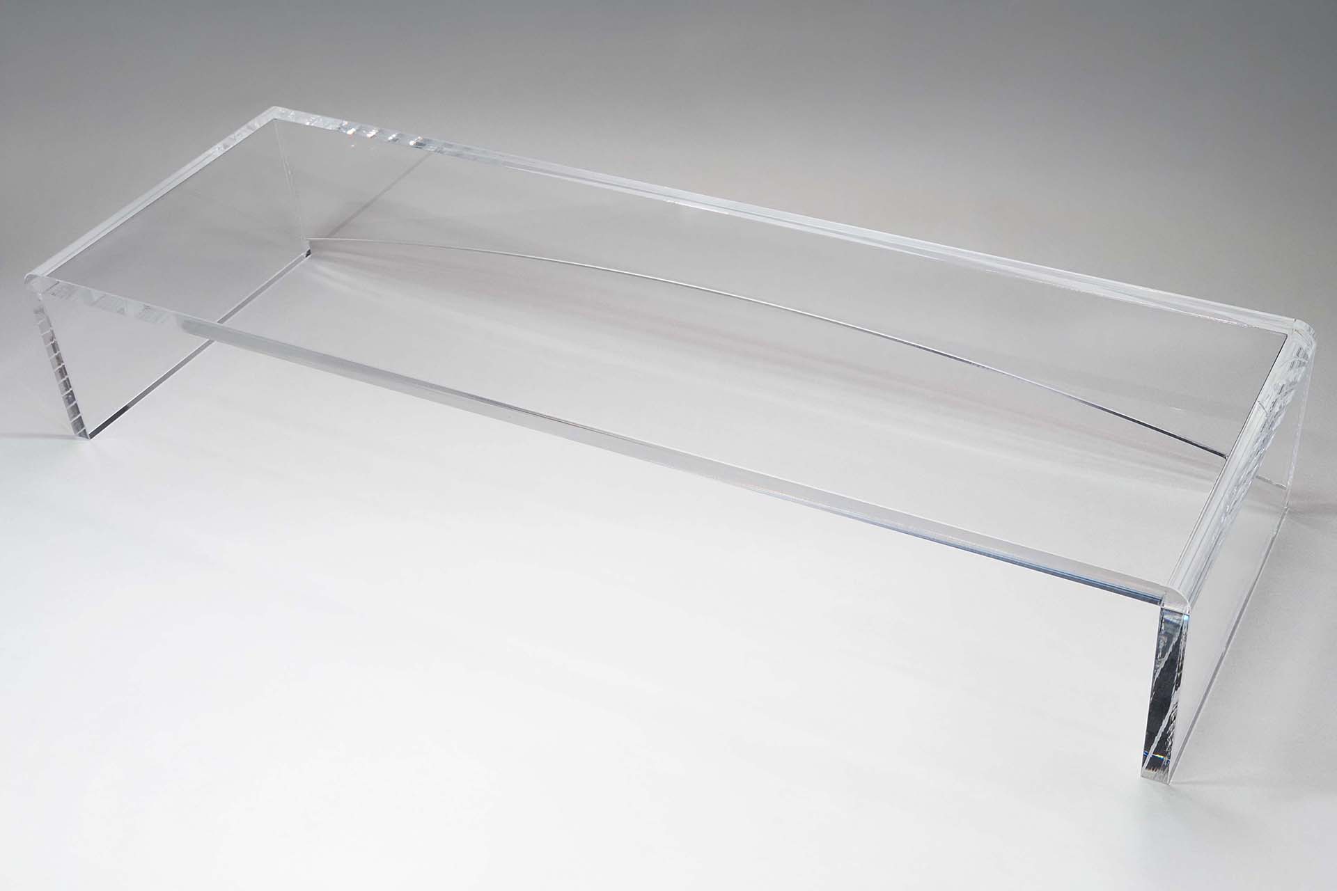 コモネット「透明アクリル製キーボードラック（セミオーダーサイズ）」。注文時に欲しいサイズを指定する必要がある。これは外寸が横幅520×高さ90×奥行170mm。5258円で購入できた。サイズは注文通りで完璧♪　もちろん傷などもナシ。透明アクリルの厚さは10mmあり、後方に剛性を高めるアーチ状プレートがあるので頑丈だ