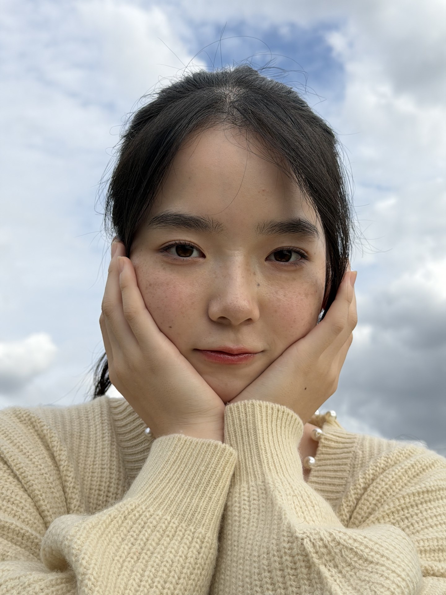 空を背景にモデルを撮った。HDRが働き、顔も空も適正な明るさになった。スキントーンもまずまずだがやや暖色傾向か（モデル：吹）