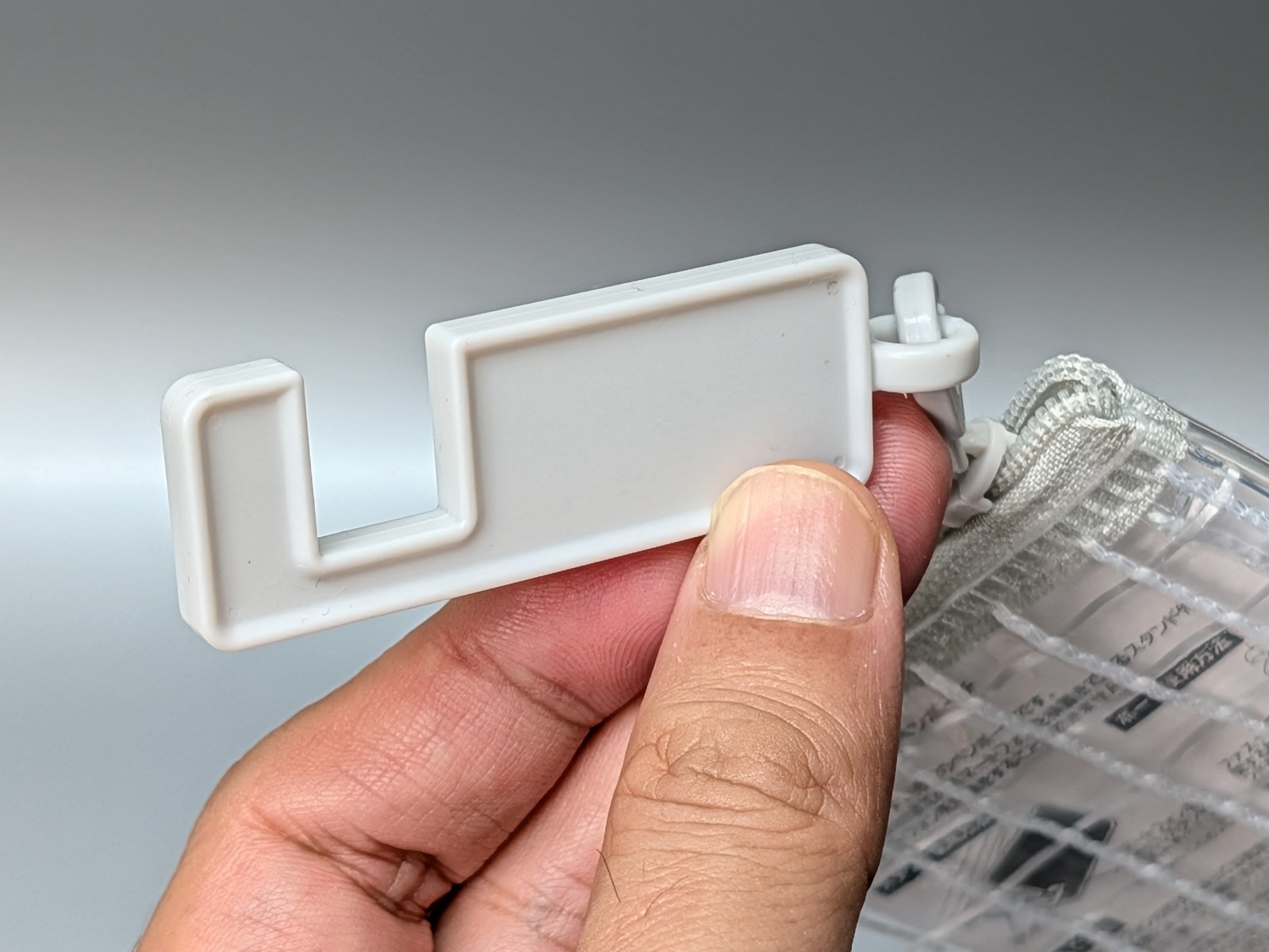 ファスナー部に、スマホを挟み込んで直立させるパーツが取り付けられている