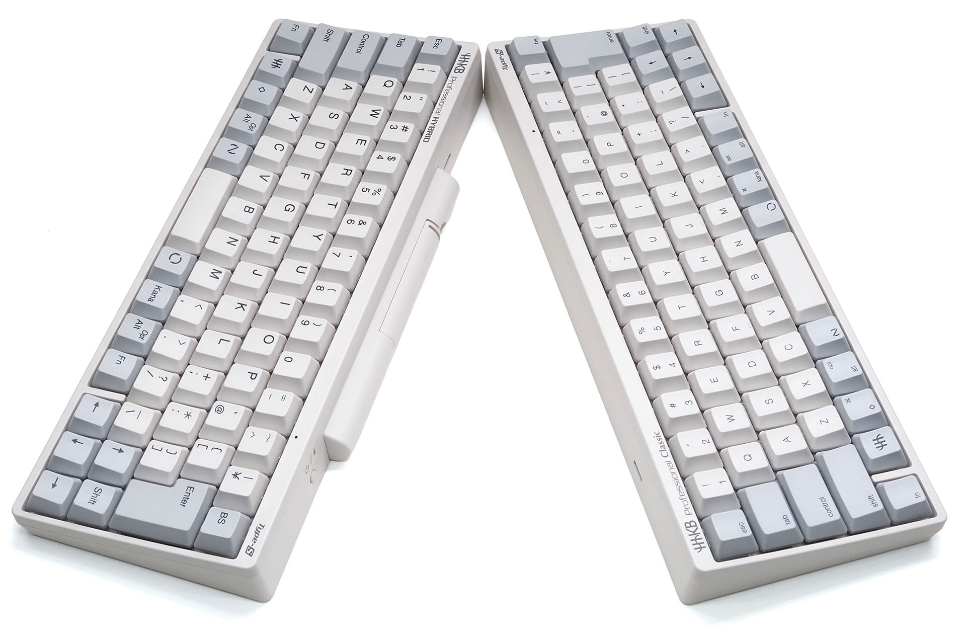 フラッグシップモデル「HHKB Professional HYBRID Type-S」（左）はBluetooth対応なので本体上に電源（単3形乾電池×2本）が要る。ので、キーボード後方に出っぱった電池室がある。新型の「HHKB Professional Classic Type-S」はUSB Type-C接続のみなので本体上に電源は不要なので電池室もない。