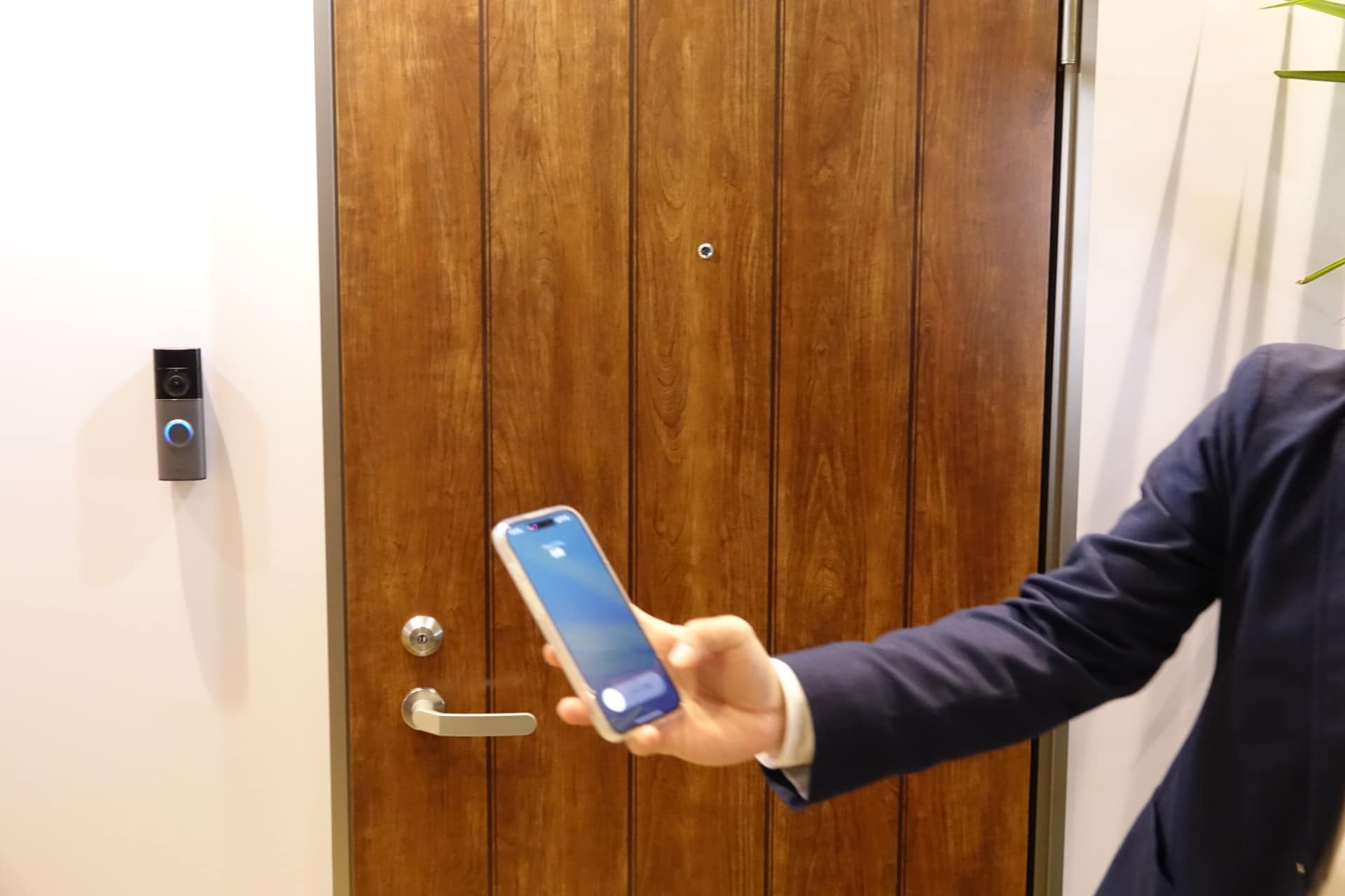 Ring Wired Doorbell Proの利用イメージ。iPhoneでは、ビデオ通話がかかってきたように、離れた場所でも応答できる。カメラは広角で、すぐ下にある置き配の荷物まで確認できる