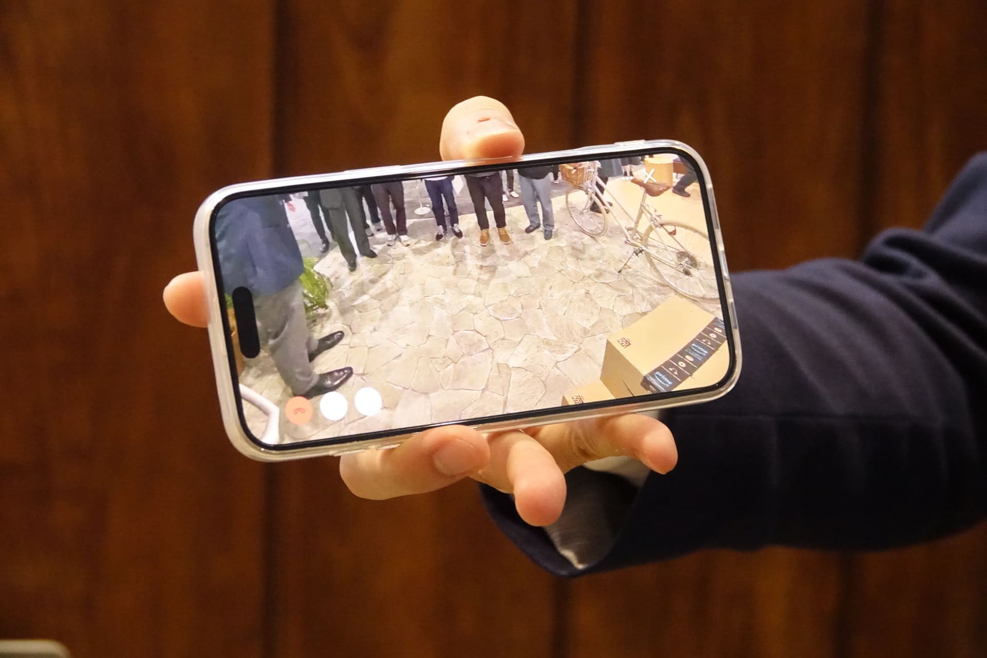 Ring Wired Doorbell Proの利用イメージ。iPhoneでは、ビデオ通話がかかってきたように、離れた場所でも応答できる。カメラは広角で、すぐ下にある置き配の荷物まで確認できる