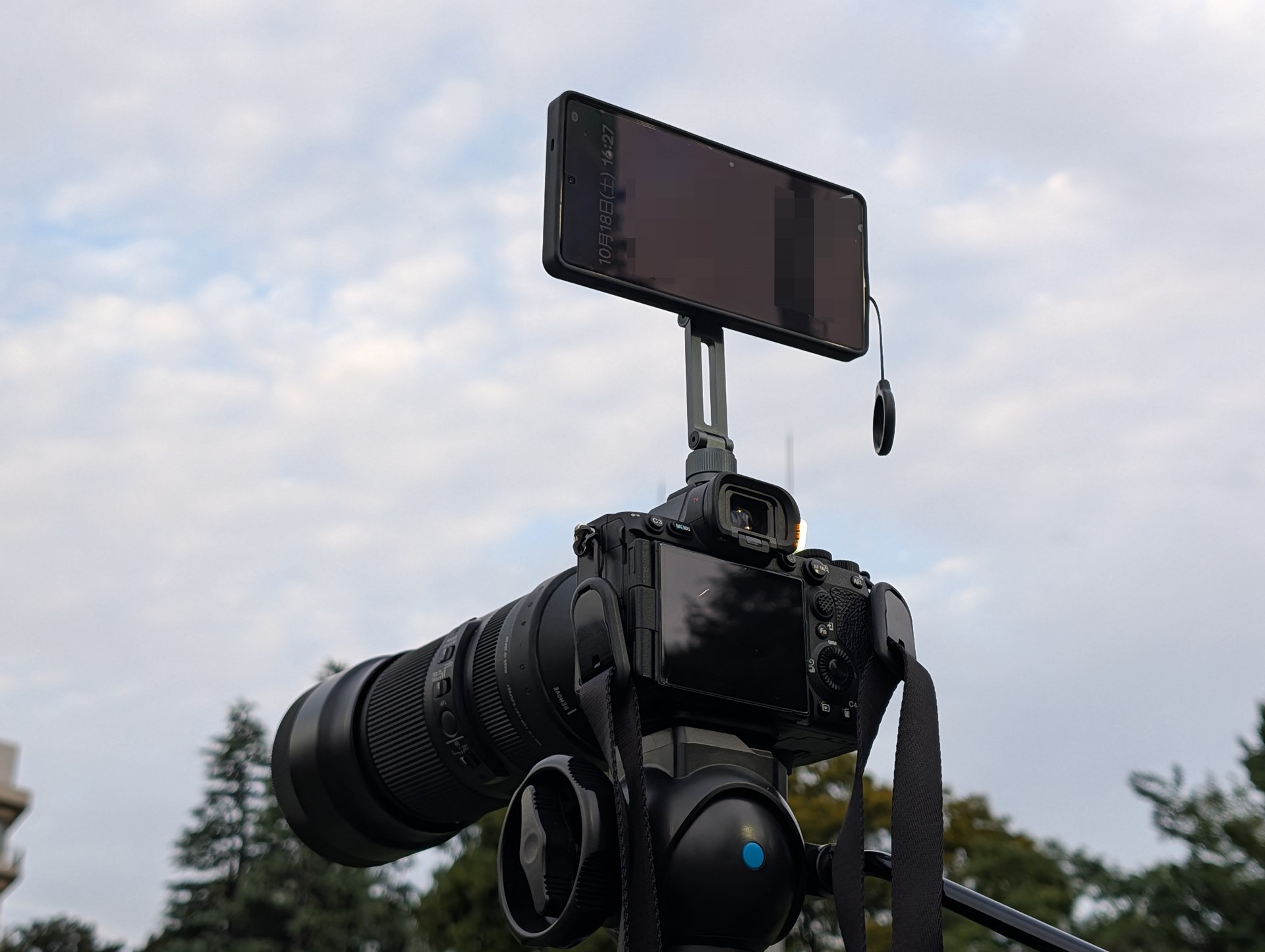 デジタル一眼レフの上にスマホを載せる。一眼レフで写真、スマホで動画を撮影