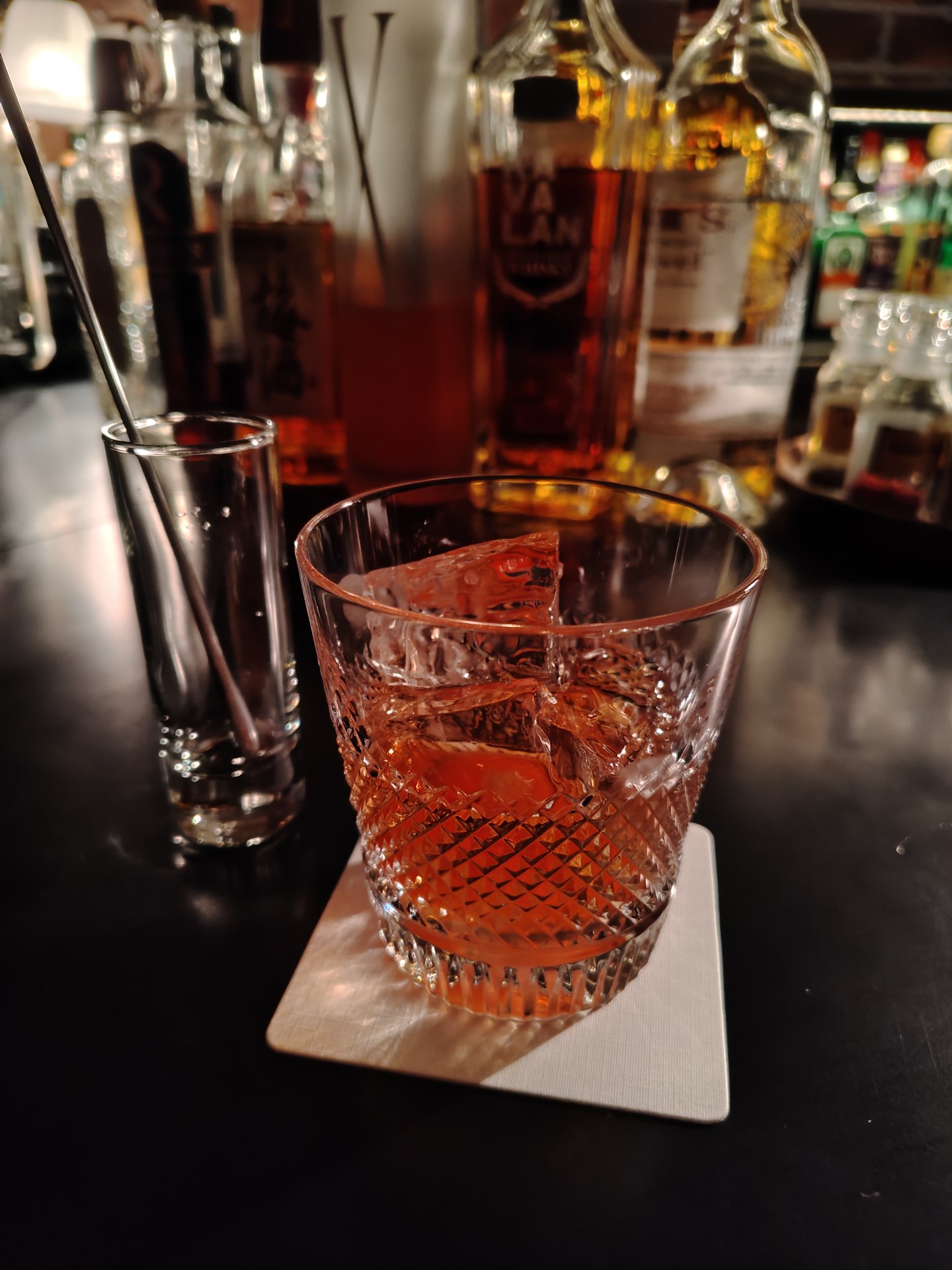 薄暗いバーで撮影。クリアなガラスとカクテルの鮮やかな赤が再現されている