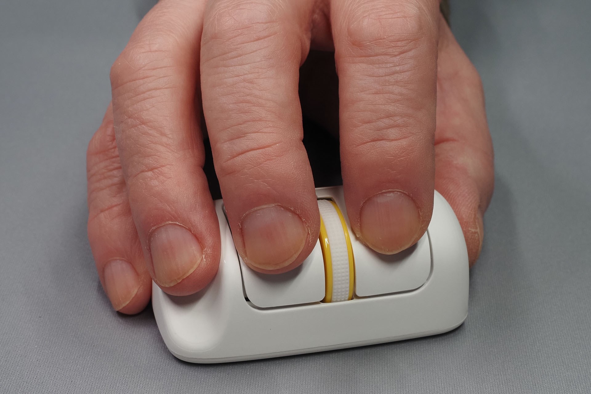「Finger Barrel Mouse i2」を持った様子。持ちづらそうに見えるかもしれないが、いつもと同じ感覚でマウスポインターを自在に操作できる。その形状から、親指も小指も机面に触れずにマウスを動かせる。