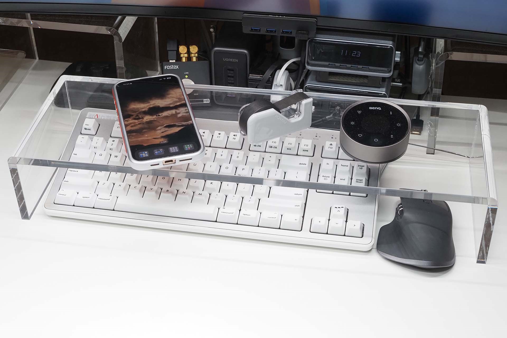 こちらはセミオーダーのアクリル製キーボードラック。キーボードを覆うようなラックで、キーボードカバーとなりつつ、キーボード上の空間にモノを置けるようになる。キーボード不使用時のホコリ避けともなってイロイロ便利。