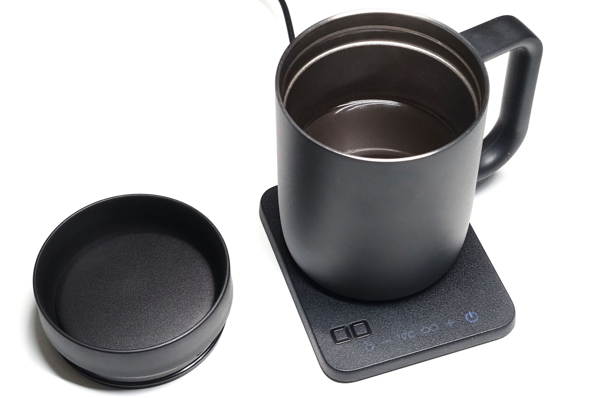 保温器として使っている様子。プレートに専用のマグカップを乗せるとマグカップ内の飲料を設定温度に保つ。付属のフタを使うと保温効果をより高められる。また、フタをしたままでも飲料を飲める。フタはマグカップに対してネジ込むタイプで、不意に外れるようなことはない。