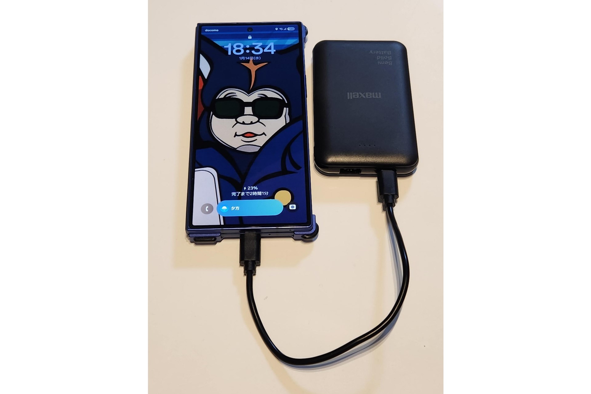 スマホを充電中のマクセル半固体電池。コンパクトなサイズ感が際立つ