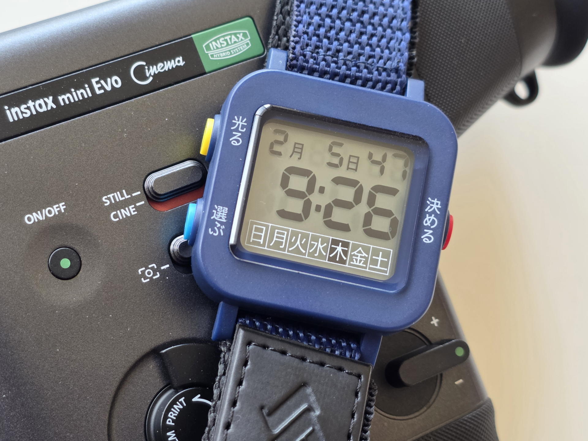 instax mini Evoの横に置かれた「やさしい時計」。ネイビーの筐体がガジェット感を引き立てる