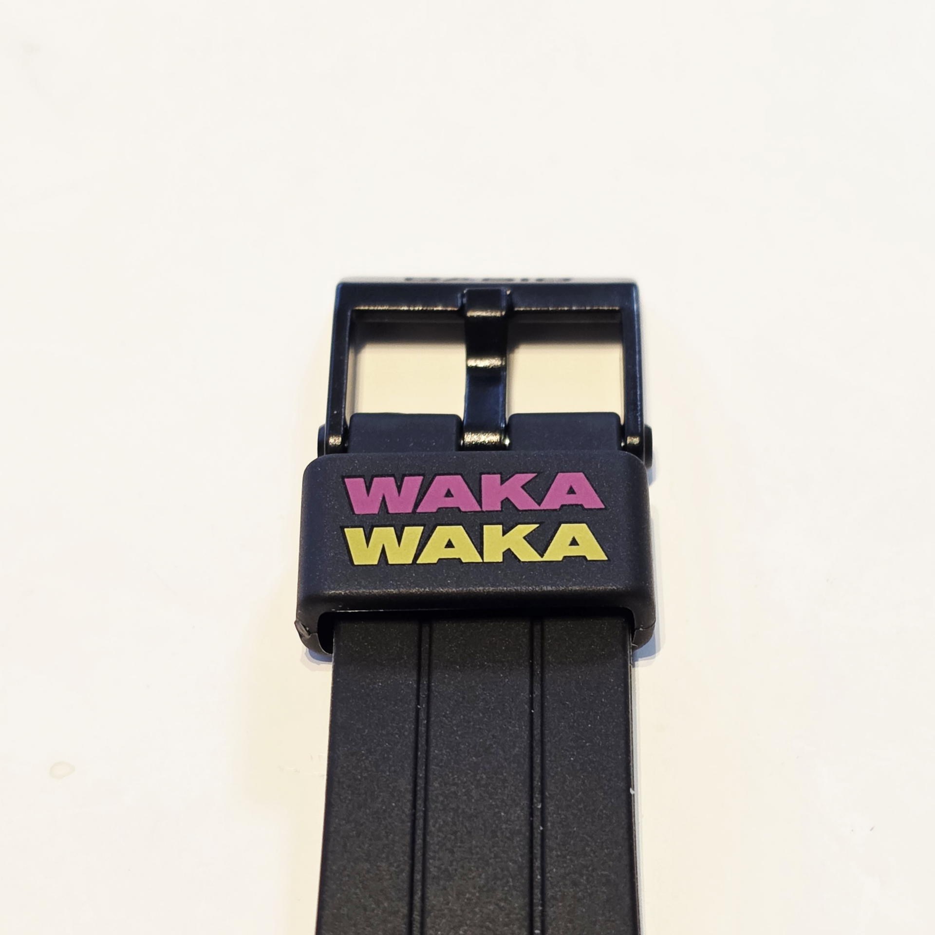 遊革に刻まれた「WAKA WAKA」の文字。イエローとピンクのネオンカラーがブラックに映える