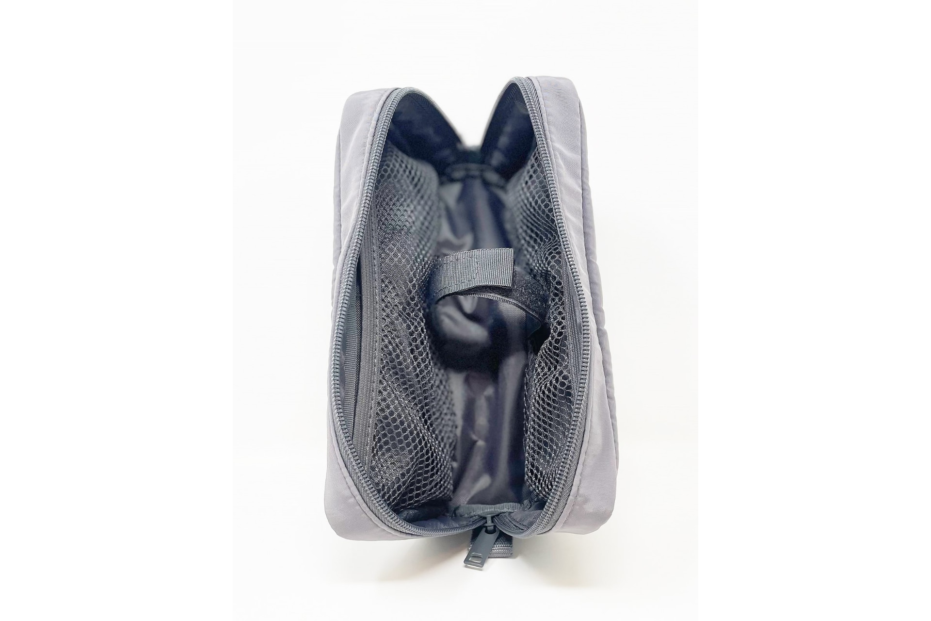 中央に入れるものを留めておくためのマジックテープ。内部の両側面にはメッシュの仕切りがあります。